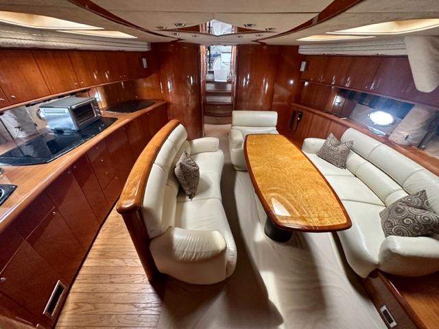 Luxurious interior of 2002 Sunseeker 75 Predator yacht with elegant seating and dining area.
