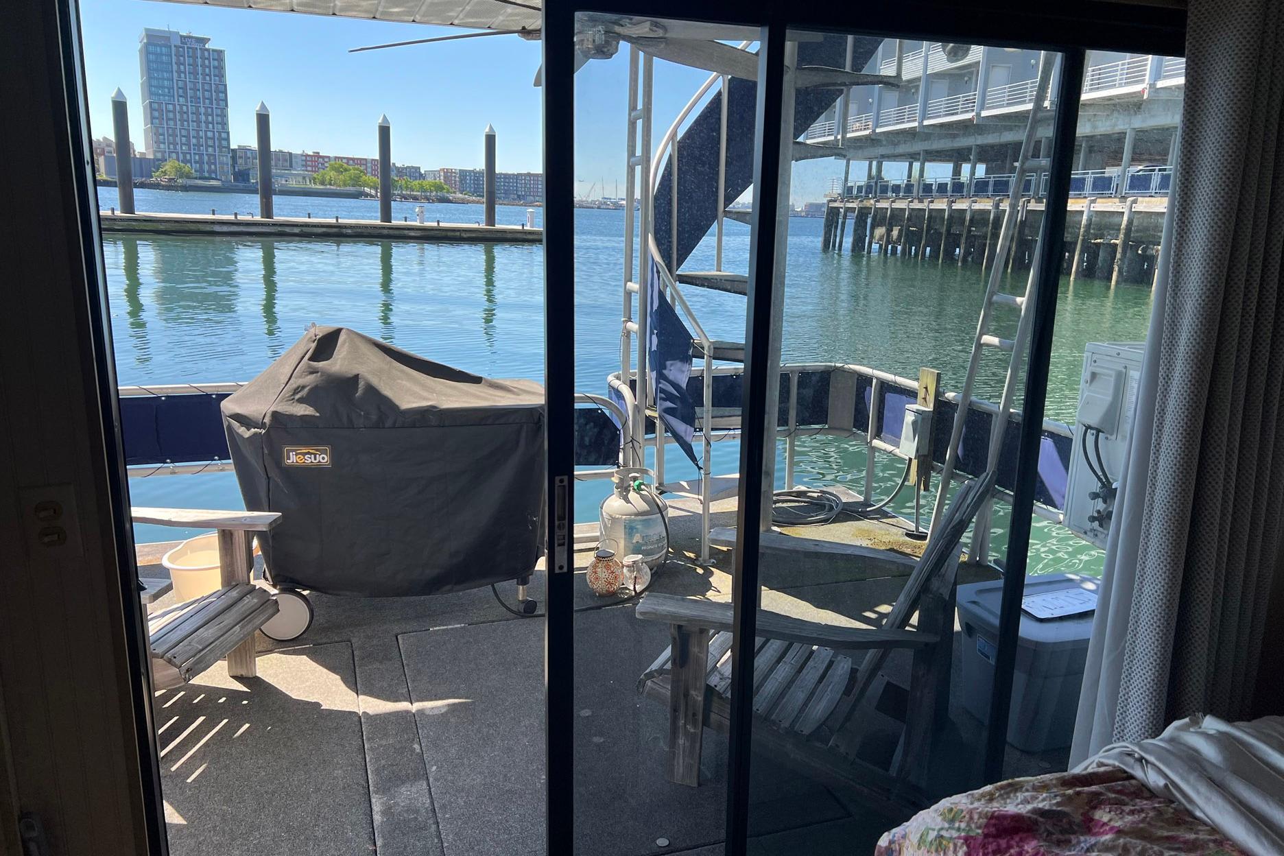 Houseboat deck view with grill, chairs, and waterfront scenery. Sumerset model, 1993.