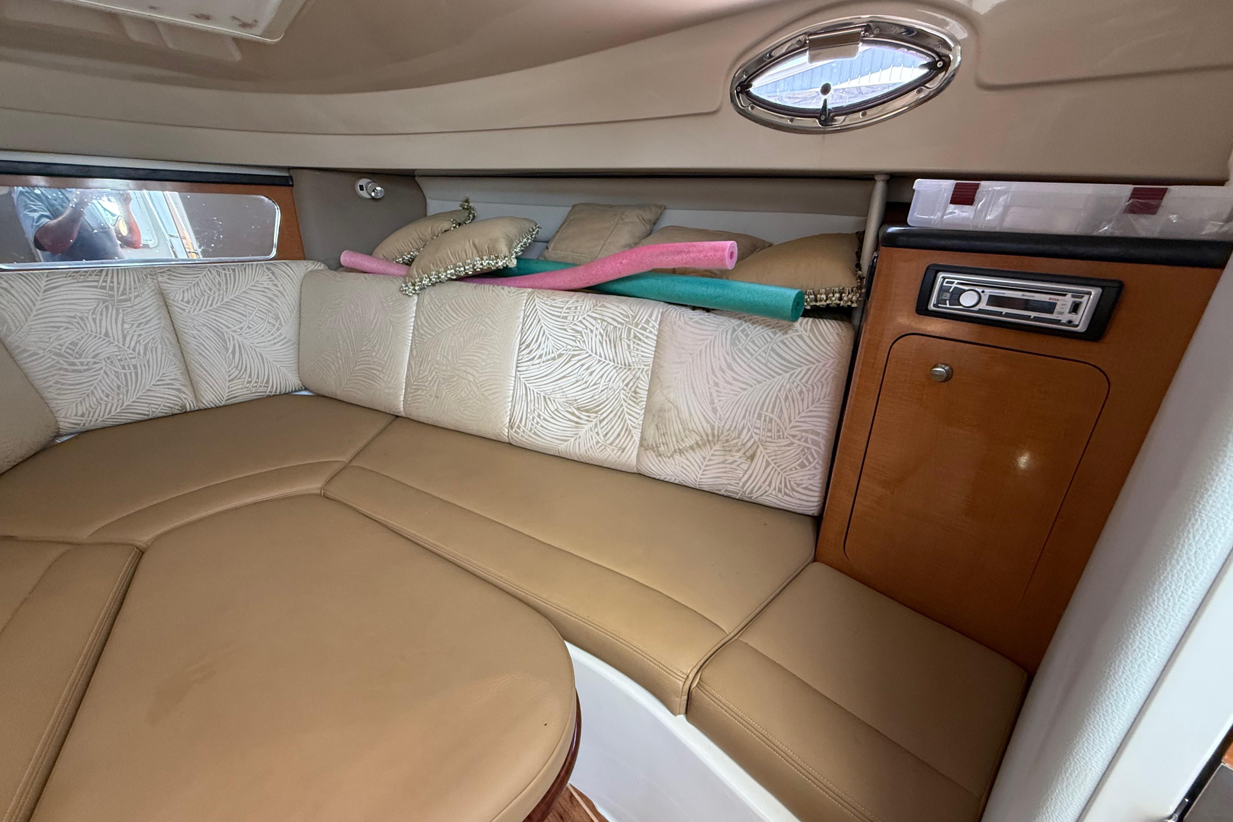 2007 Robalo R305 Walkaround cabin interior with beige seating and wood accents.