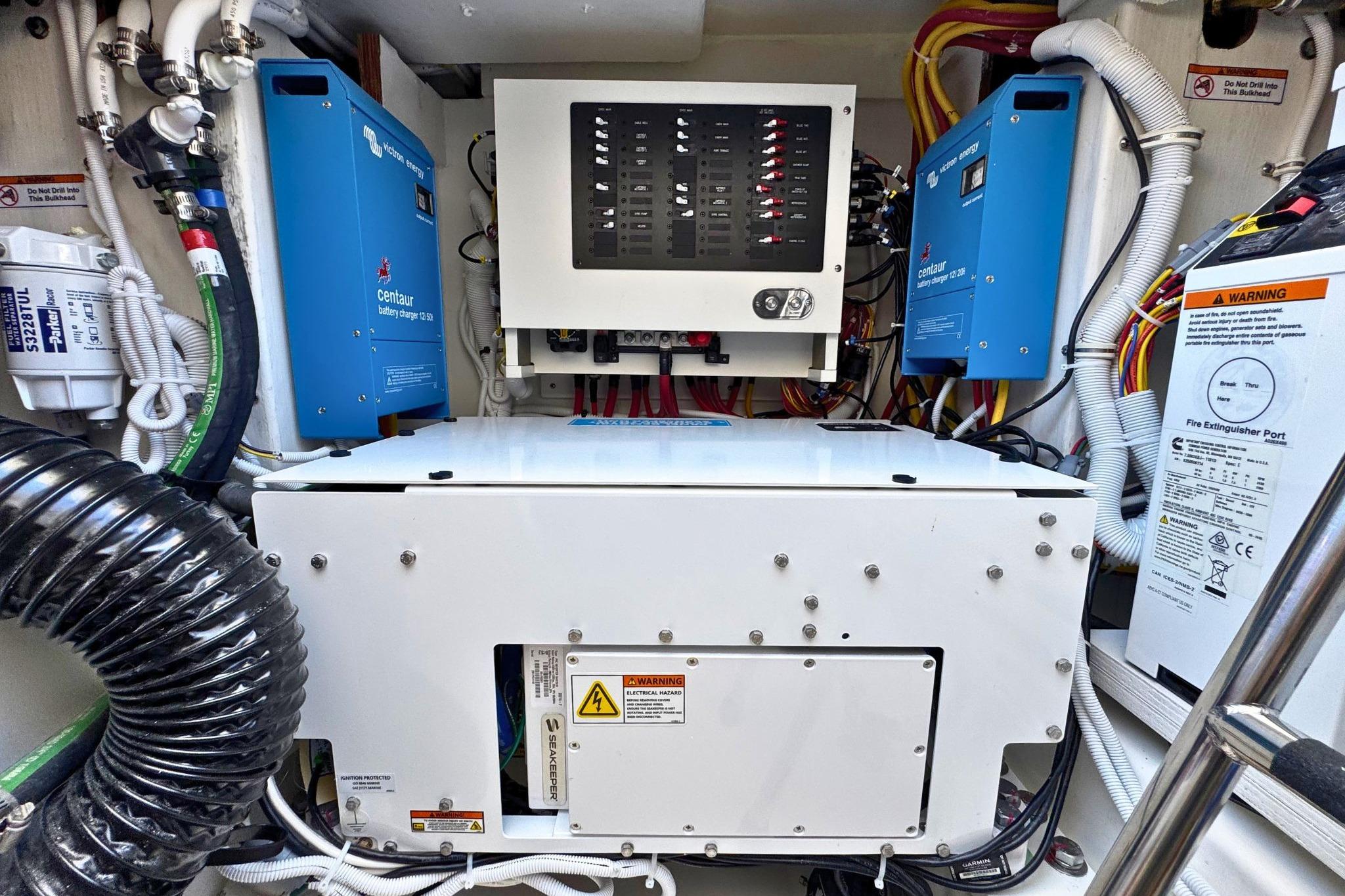 Engine room of 2027 Tiara Yachts 39 LE, featuring electrical systems and battery chargers.