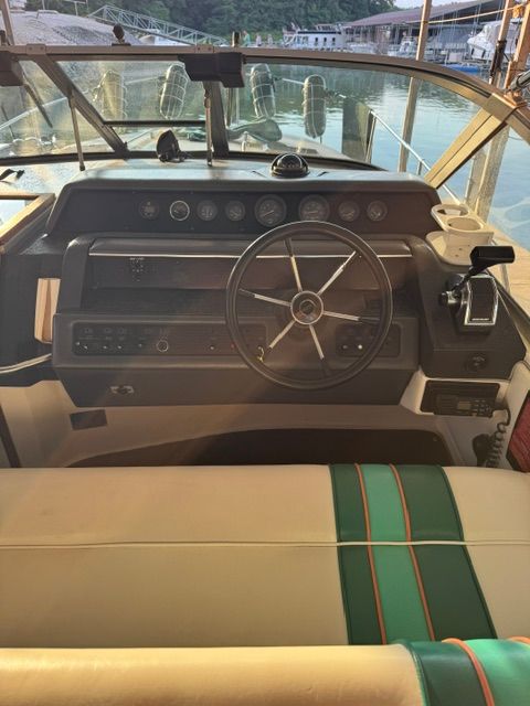 The image shows the cockpit of a 1992 Sea Ray 290 Sundancer with a steering wheel and instruments.