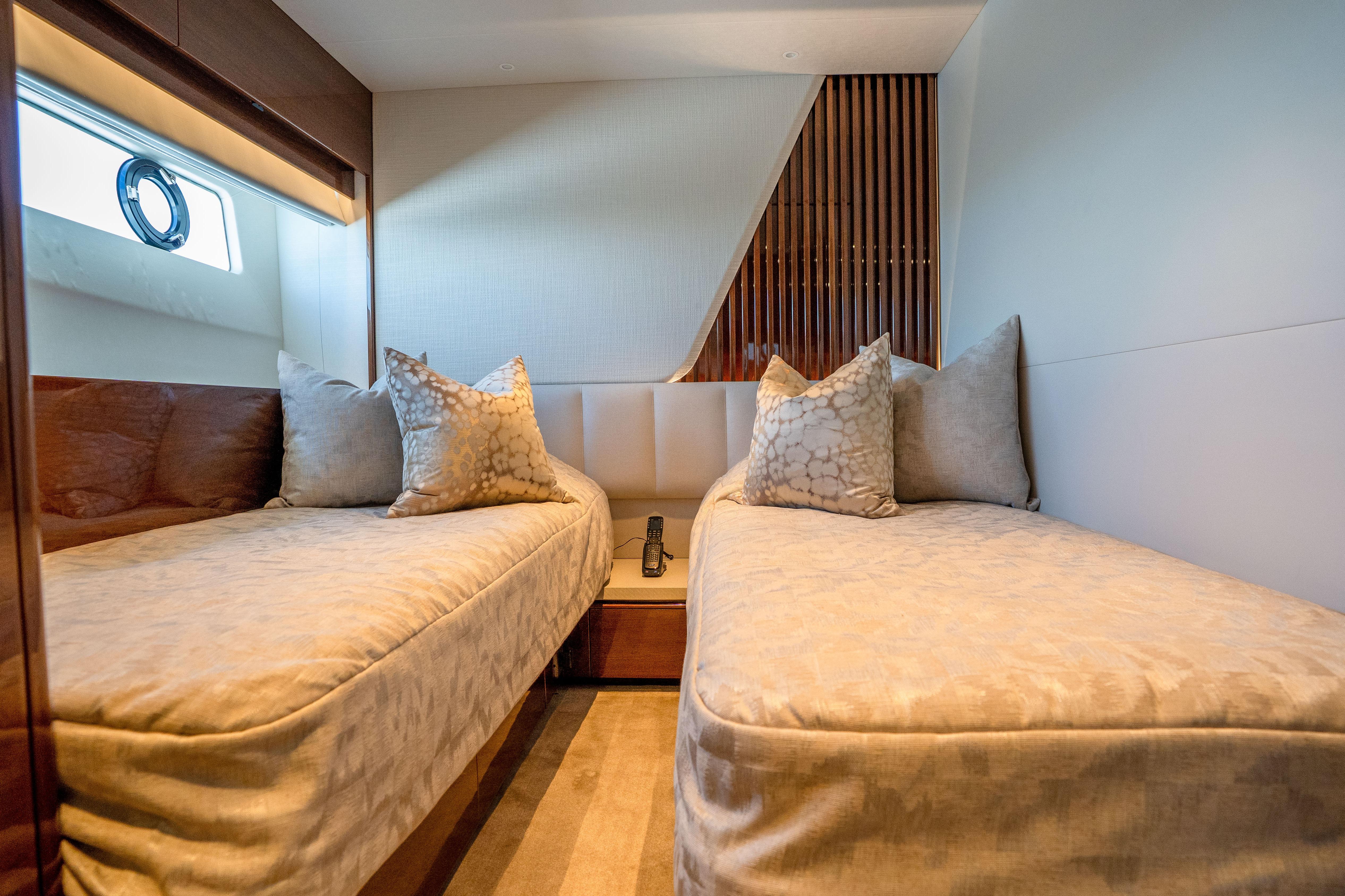 Luxurious twin cabin interior of 2020 Princess Y85 yacht with elegant bedding and decor.