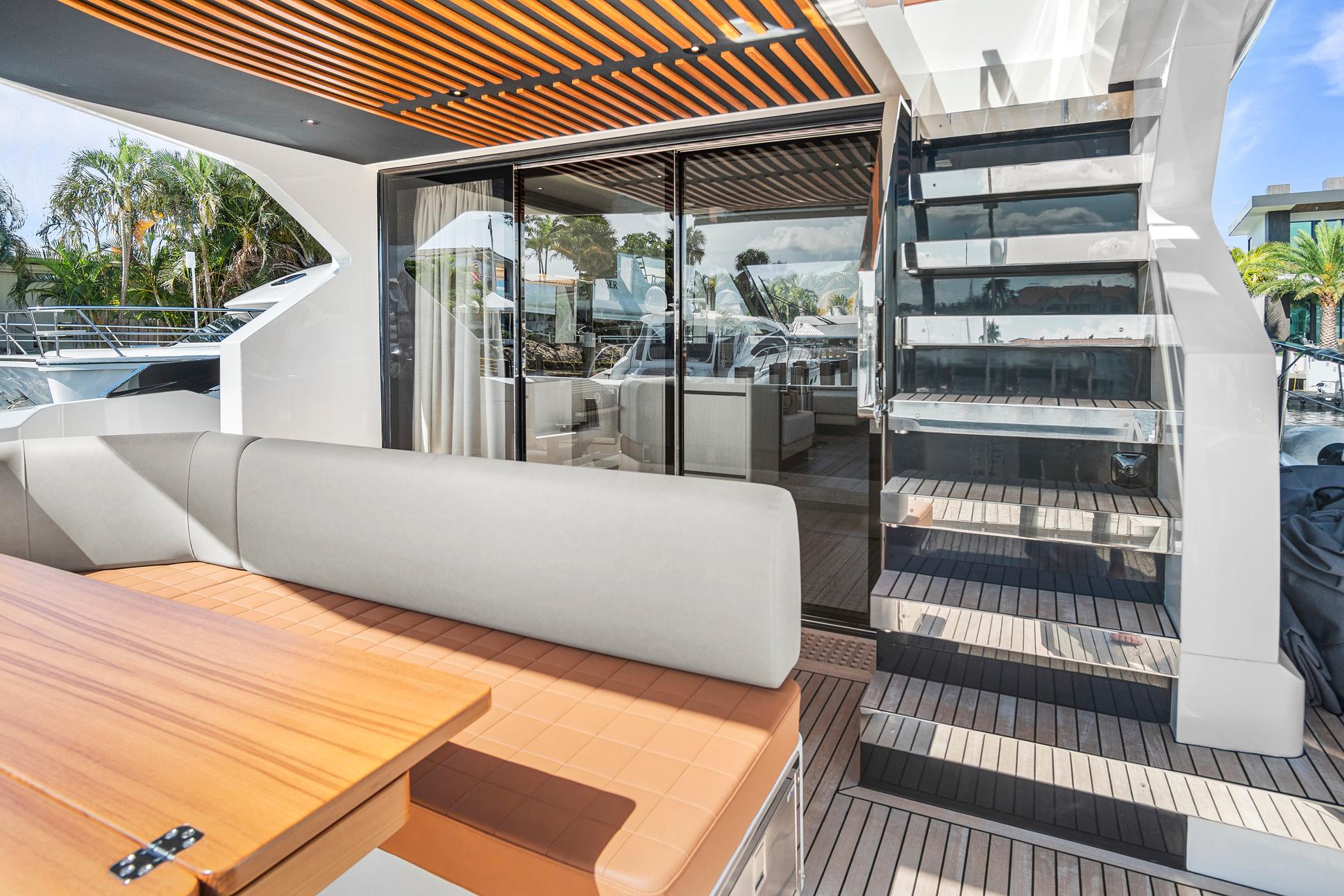 Luxurious 2023 Astondoa AS5 yacht deck with modern seating and glass staircase.