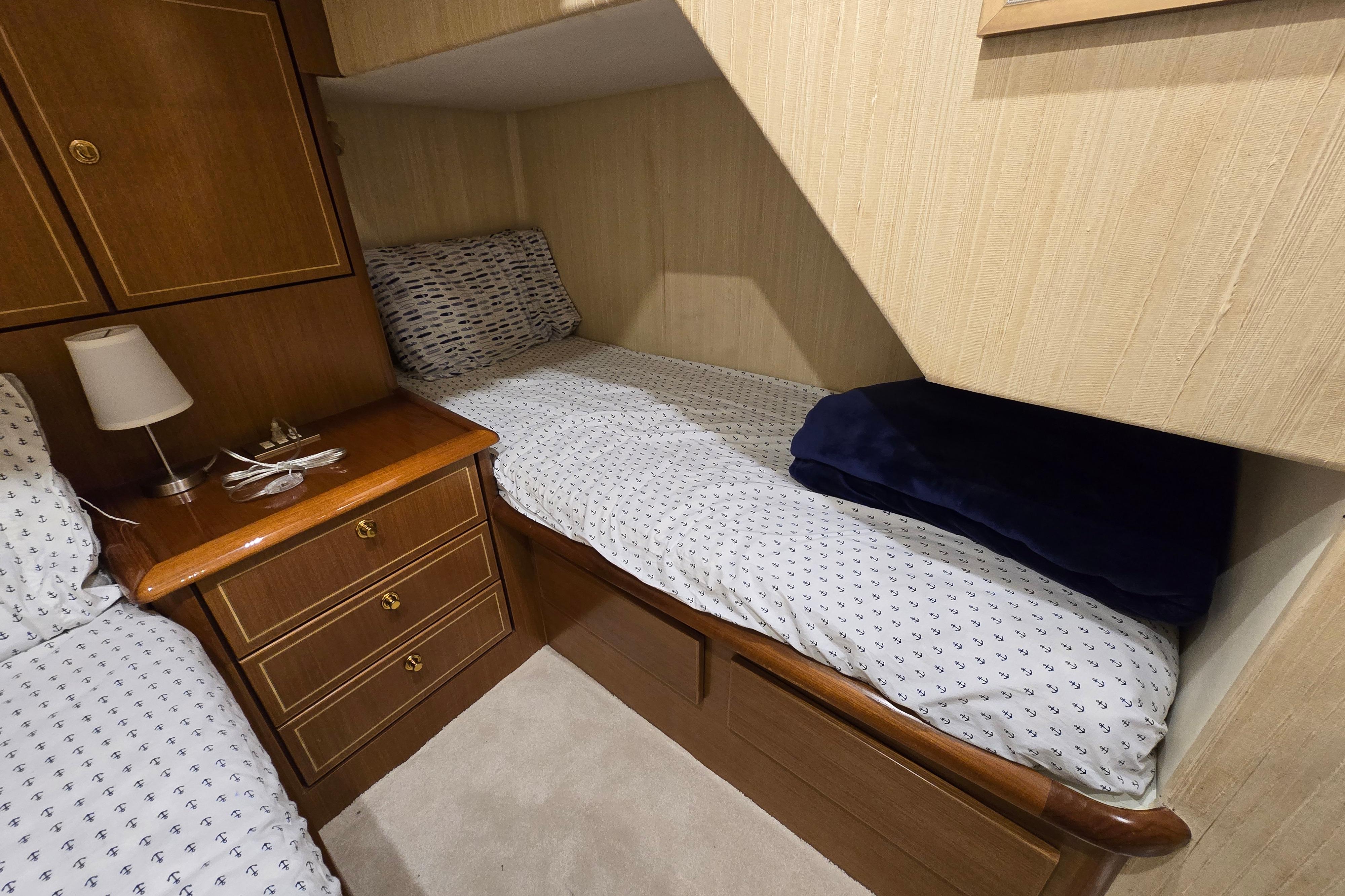Cozy cabin interior of 2004 Ocean Yachts 50 Super Sport with wooden furnishings and bedding.