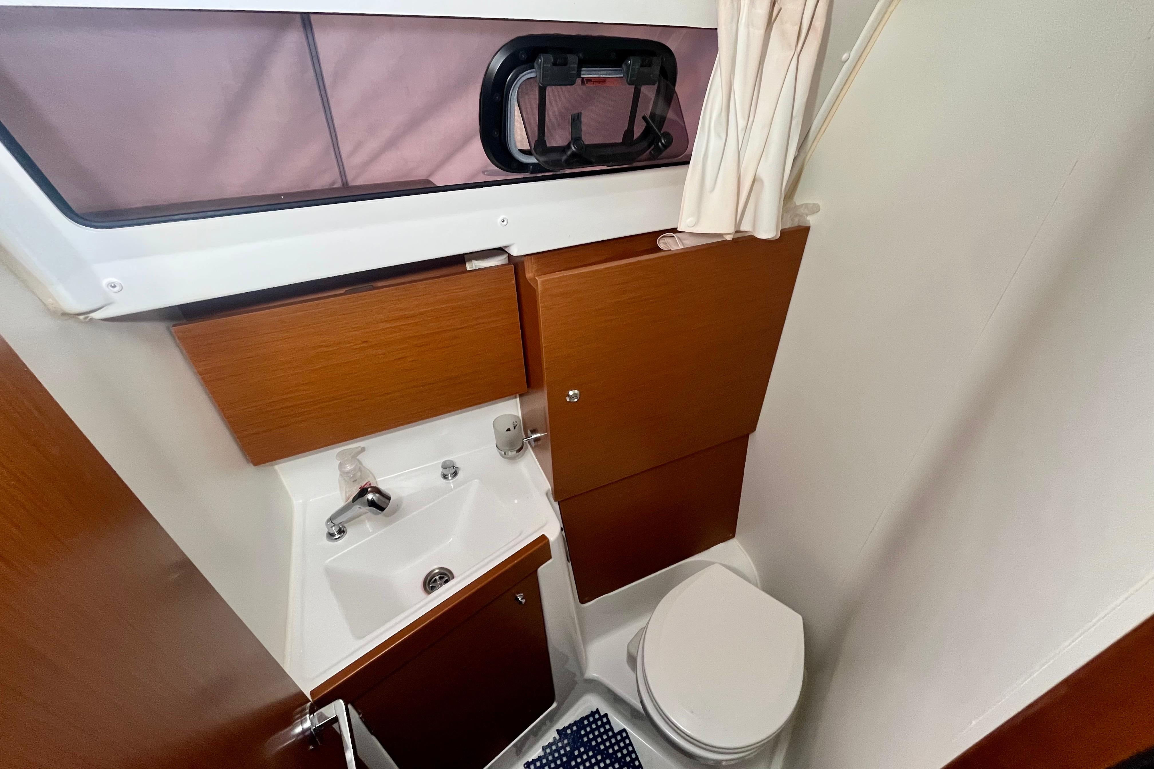 2019 Beneteau Oceanis 35.1 bathroom with wooden cabinets, sink, and toilet.