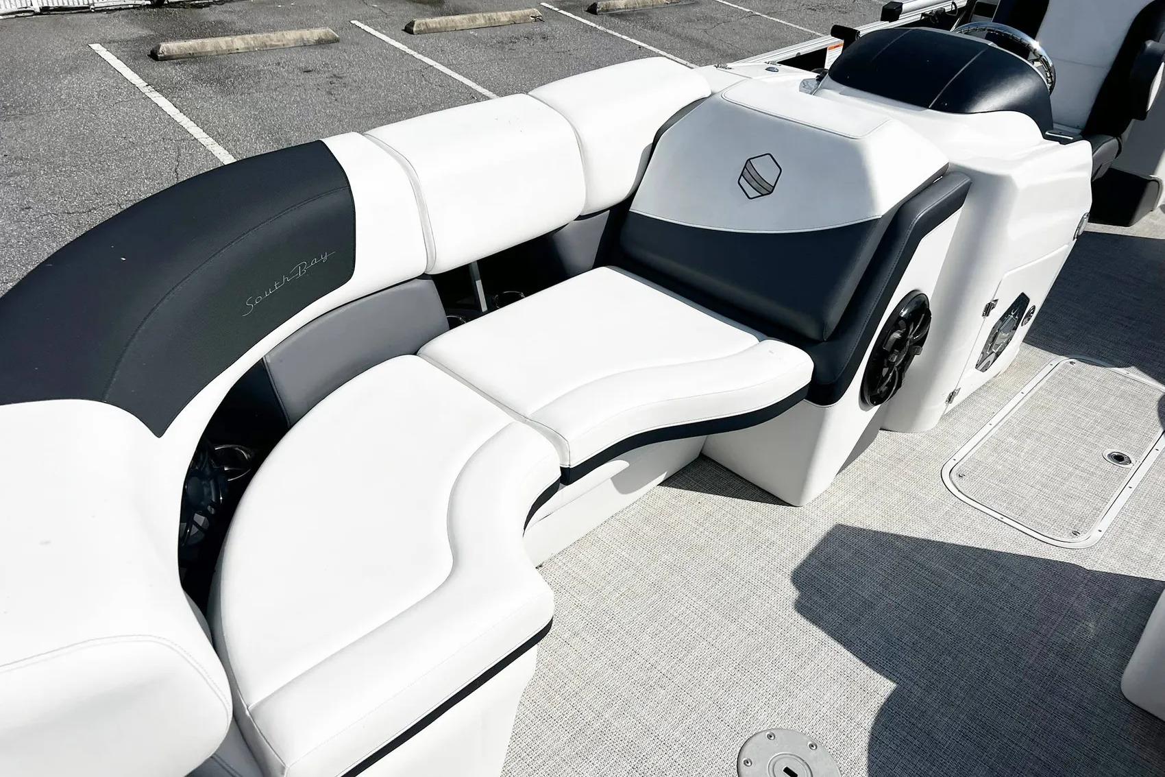 2023 South Bay 523 R boat interior with white and black seating in a parking lot.