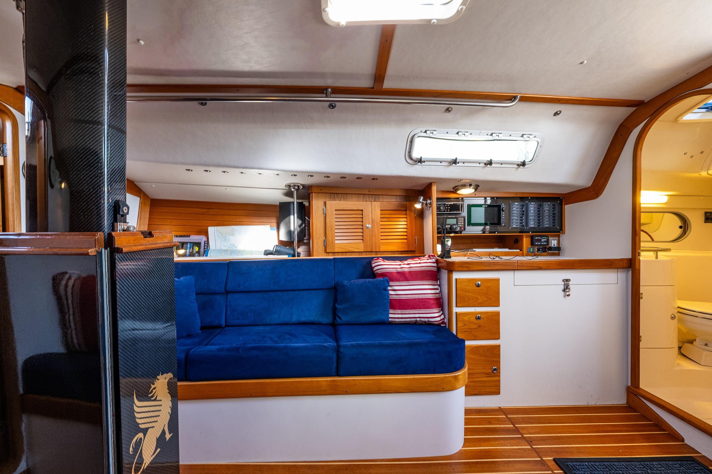 Interior of 2007 J Boats J/124 yacht with blue seating, wood accents, and navigation equipment.