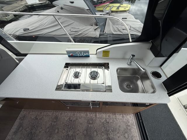 The galley on a boat with two burners and a sink.