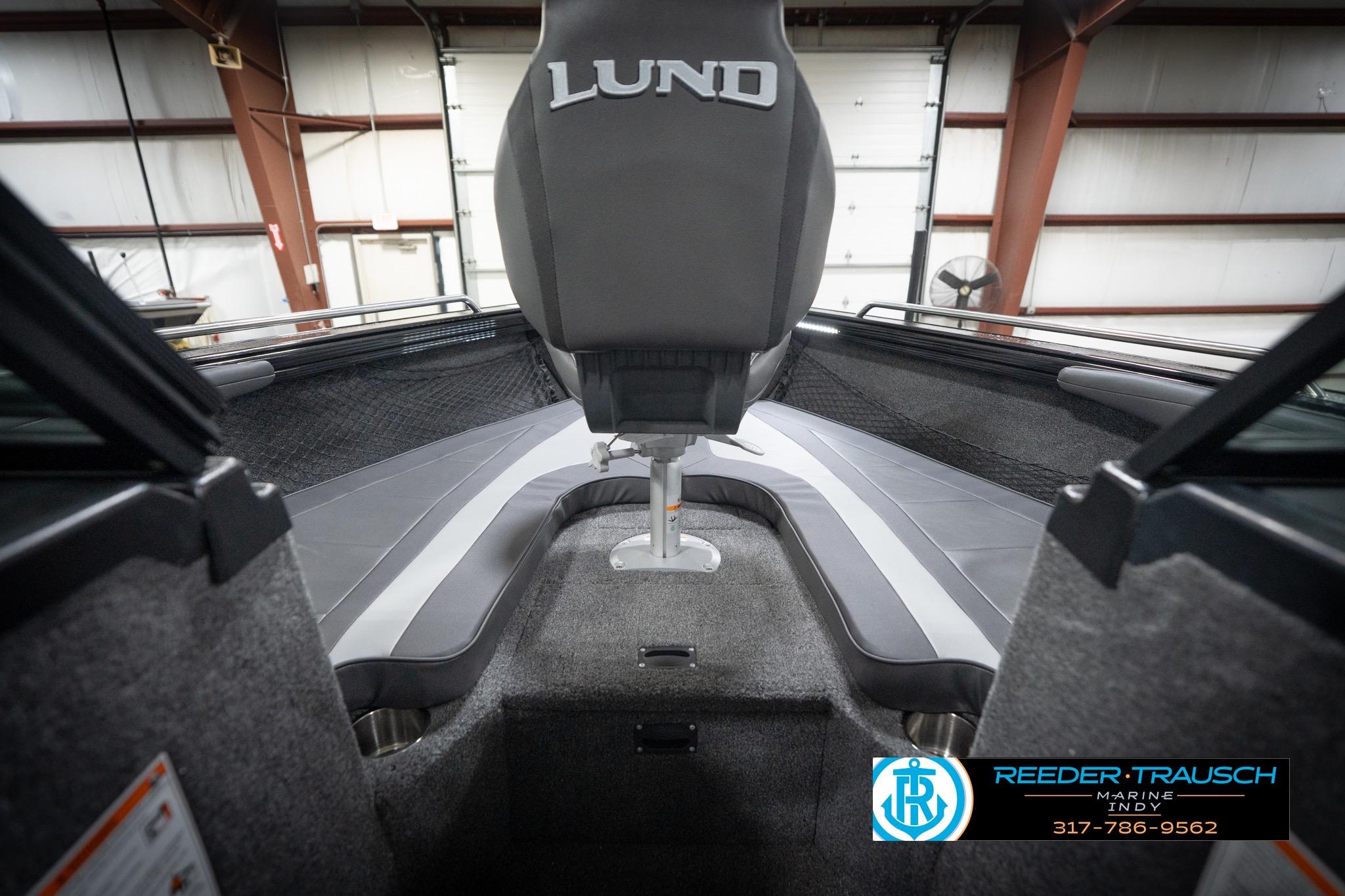 2026 Lund 2275 Baron boat interior with seating and logo, displayed in a showroom.