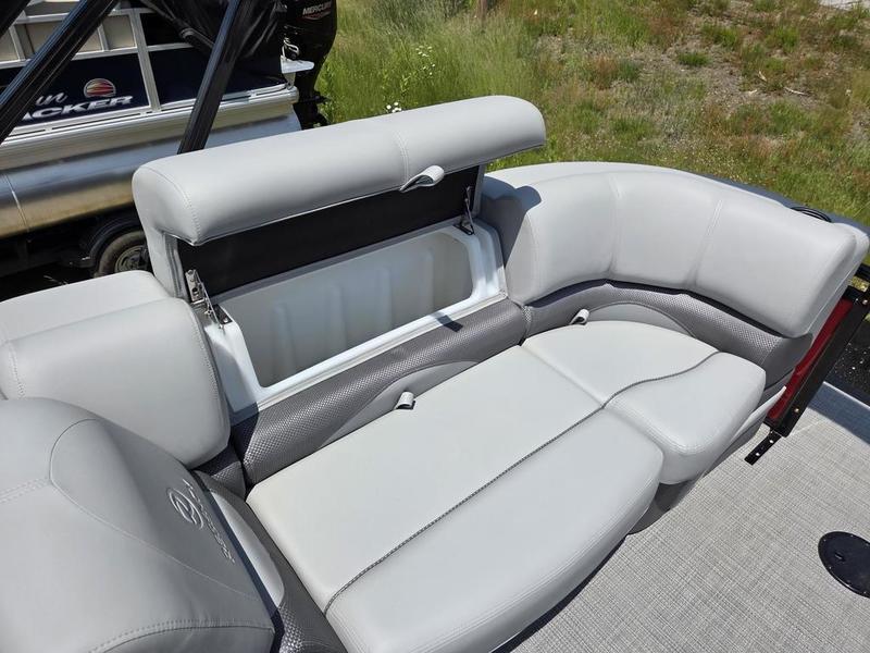 2025 Regency 230 DL3 boat with open storage compartment on gray cushioned seating.