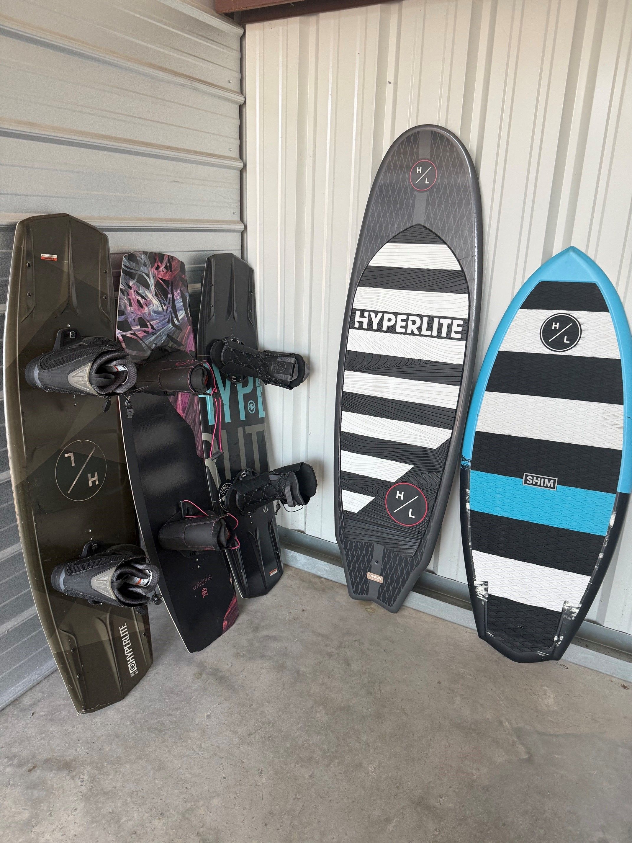 Wakeboards and surfboards stored in a garage.
