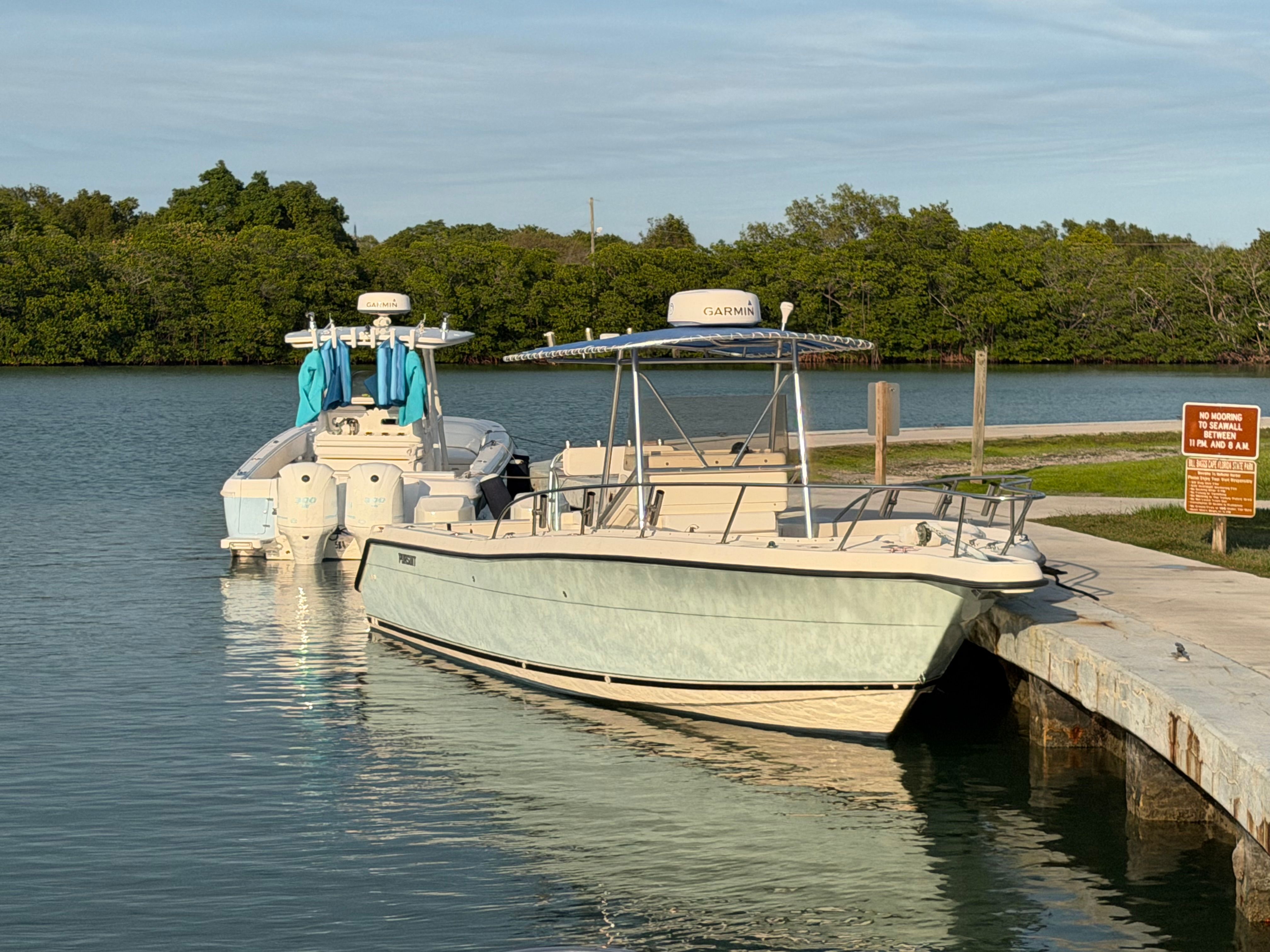 2004 Pursuit 2870 boat docked on calm water.