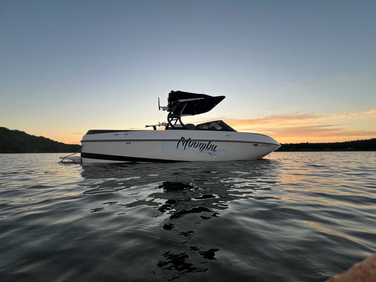 A 2017 Moomba Craz boat floats on calm water at sunset.