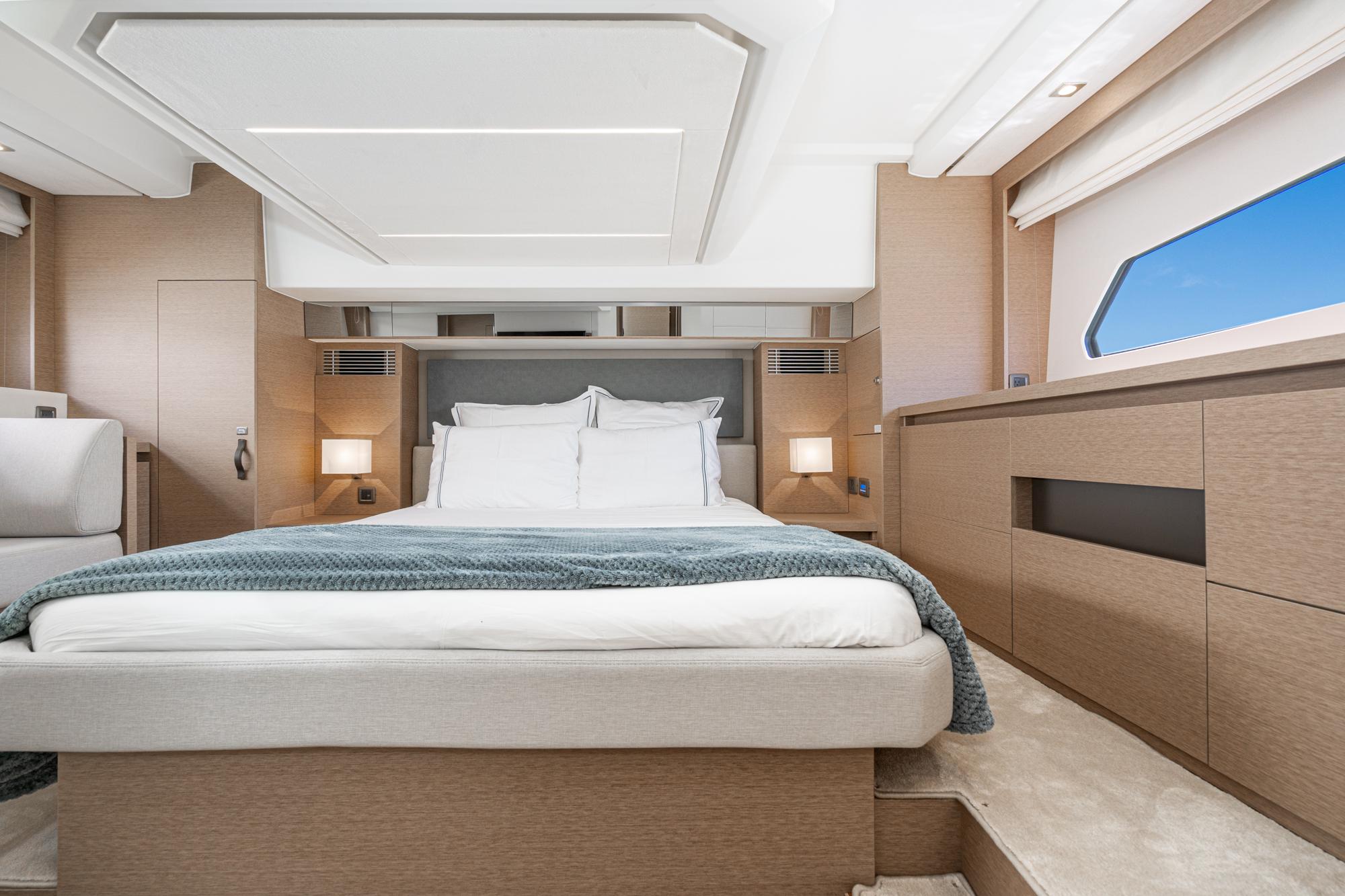 Luxurious bedroom interior of 2022 Prestige 460 yacht with modern design and ample natural light.