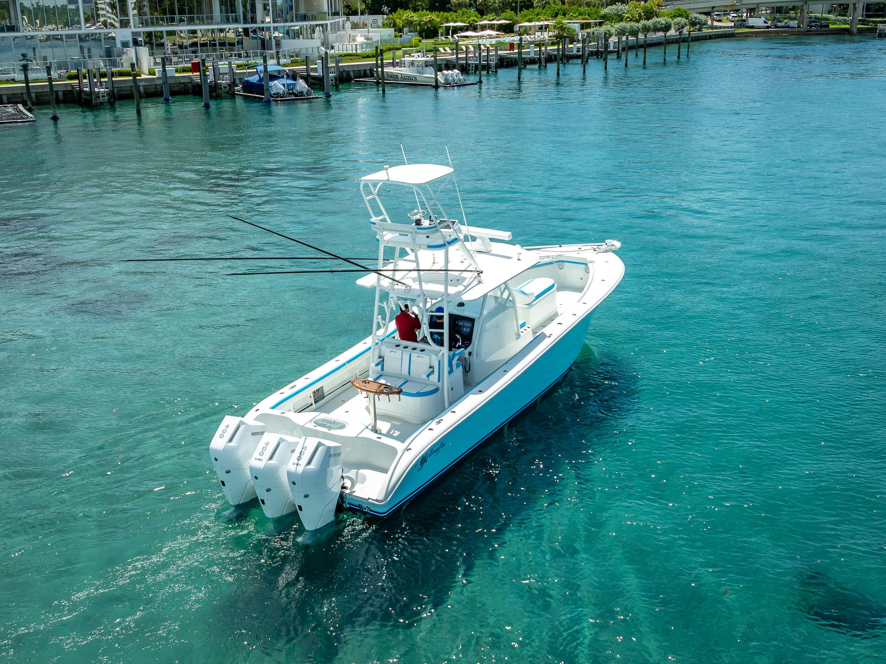 2016 Yellowfin 39 Offshore boat cruising in clear blue water near a marina.