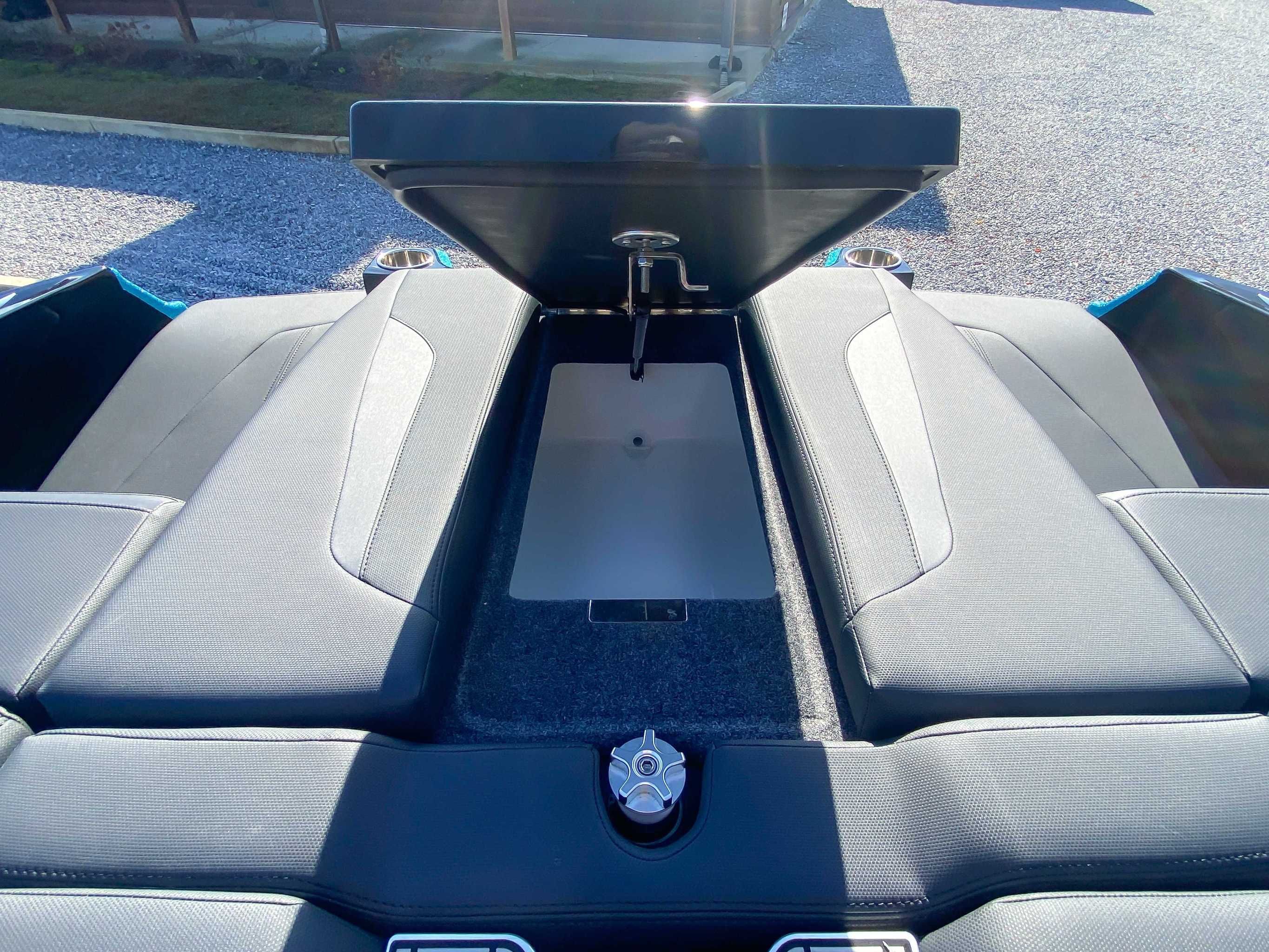 2024 MasterCraft XStarS boat with open storage compartment lid.