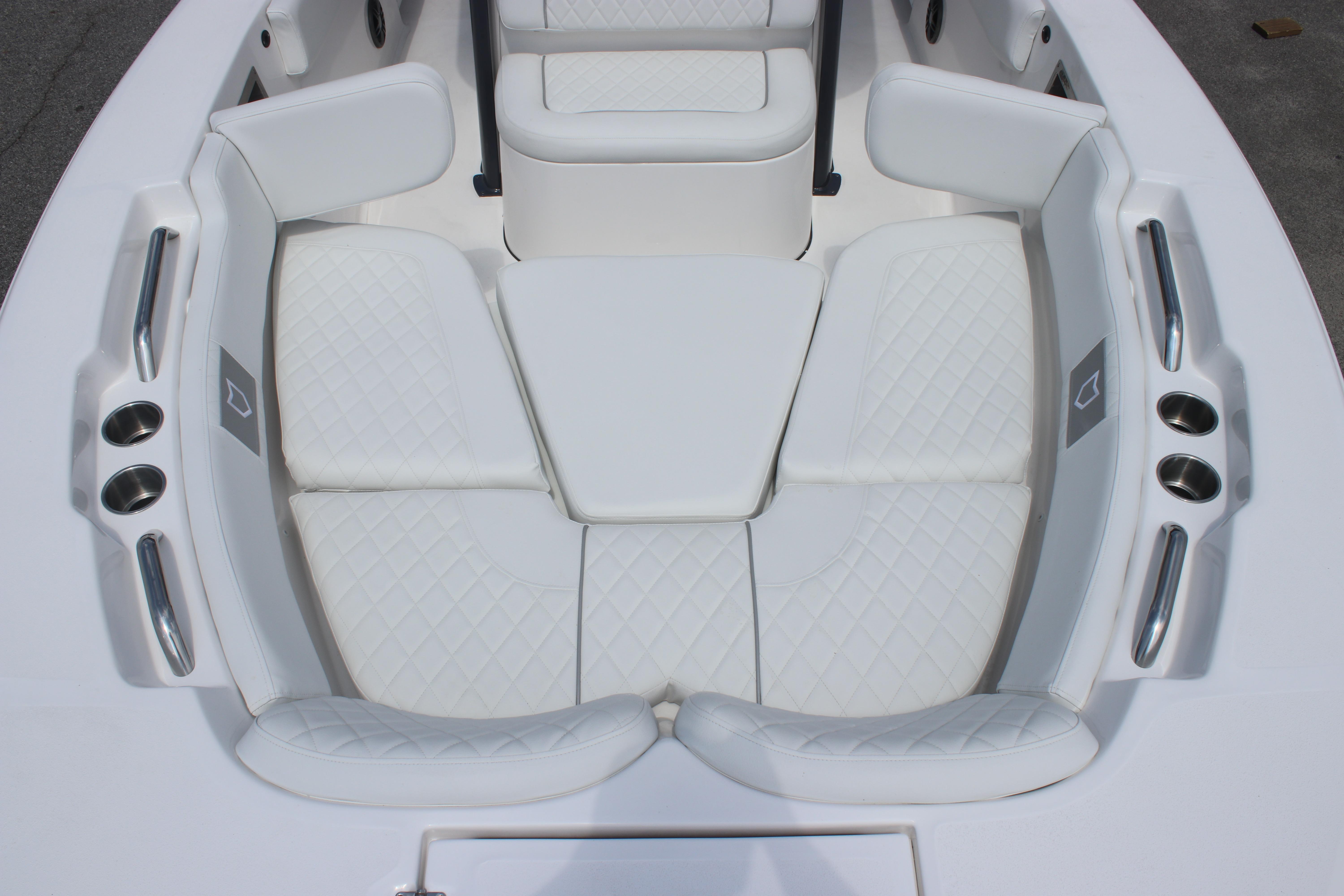 2026 Sea Fox 248 Commander boat interior with white cushioned seating and cup holders.