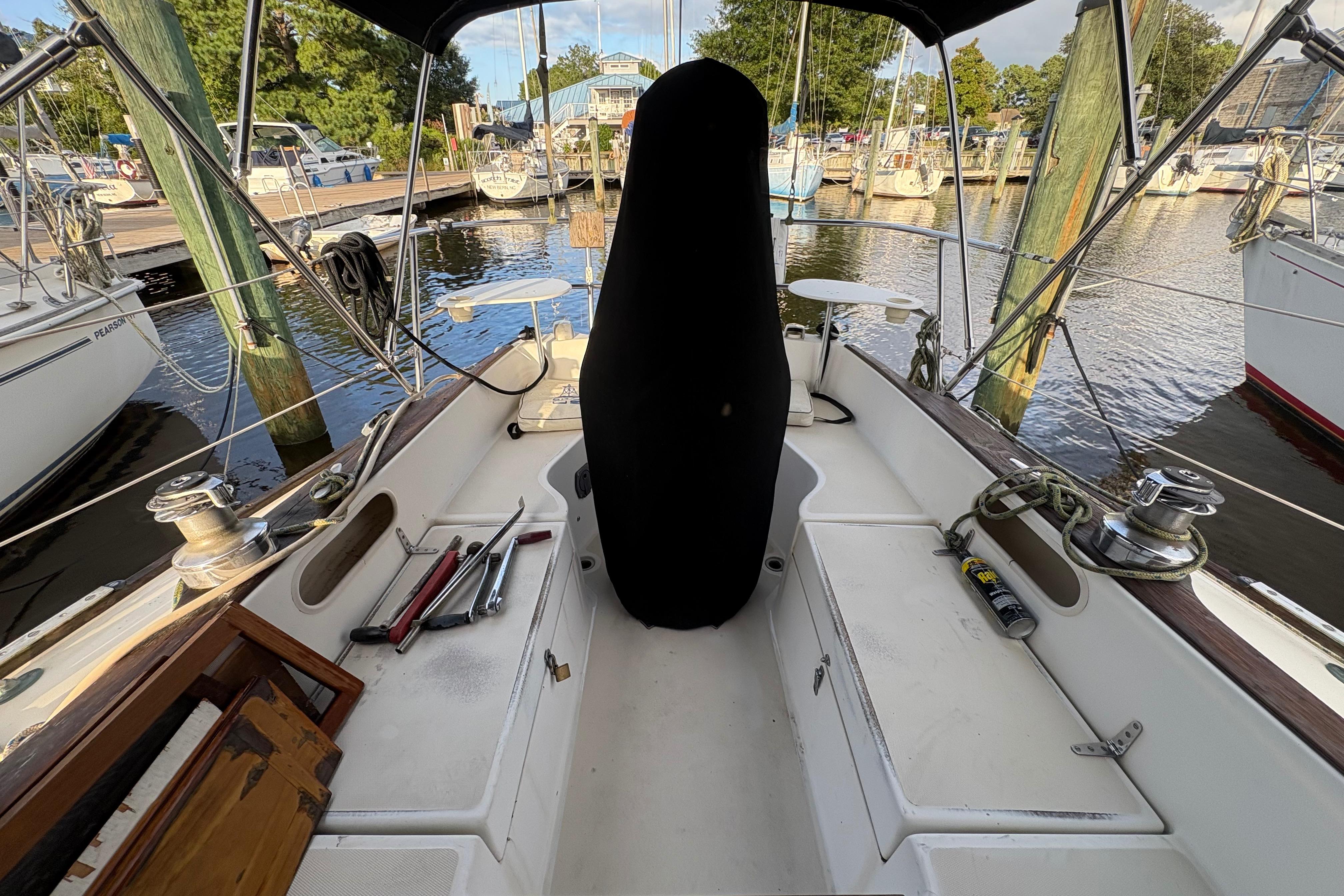 Cockpit of 1981 Sabre 31 sailboat docked at marina, featuring winches and covered helm.