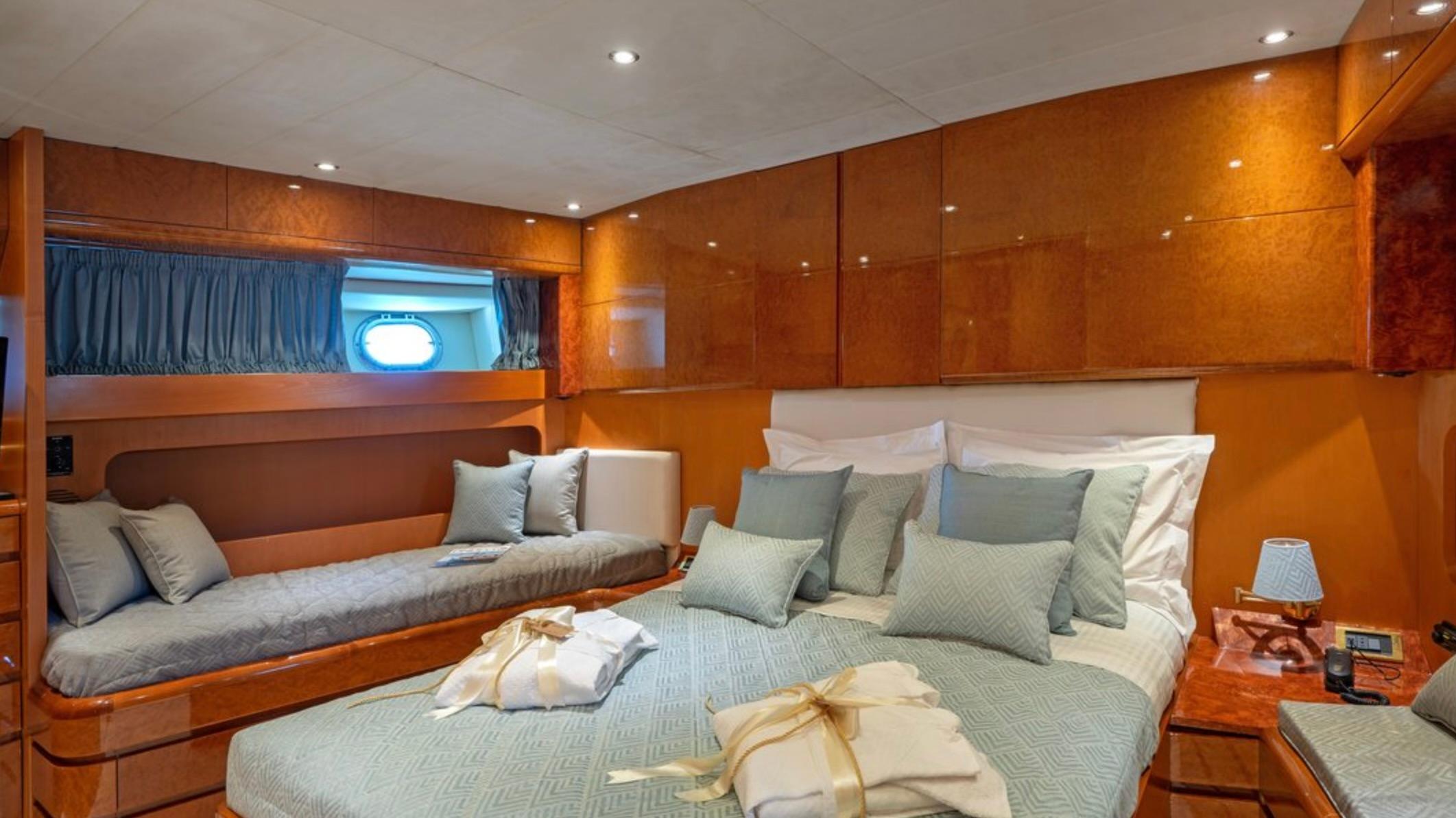 Luxurious cabin interior of 1992 Maiora 28 Flybridge yacht with elegant bedding and wood paneling.