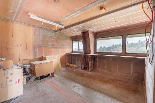 Interior of unfinished 2025 Catamaran Bloomfield 86 Motorsailor with large windows and construction materials.