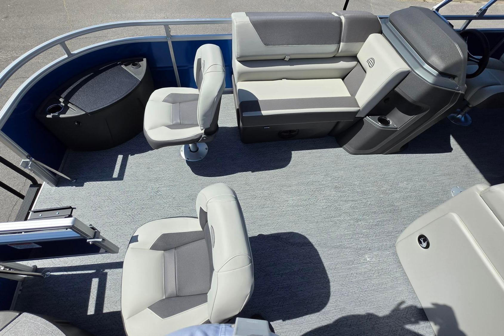 2026 Sun Tracker Fishin' Barge 20 DLX interior with seating and helm, showcasing spacious layout.