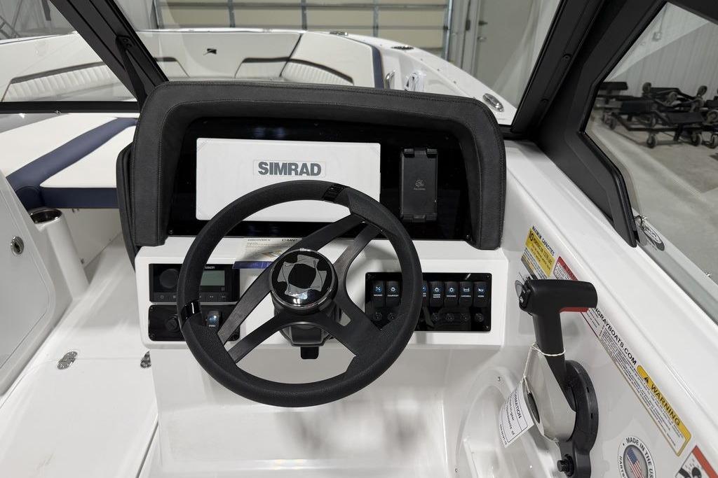 Cockpit of 2027 Stingray 20 SBX boat with Simrad navigation system and steering wheel.