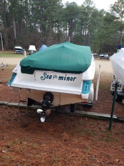 1996 Wellcraft 2400S boat with green cover parked outdoors.