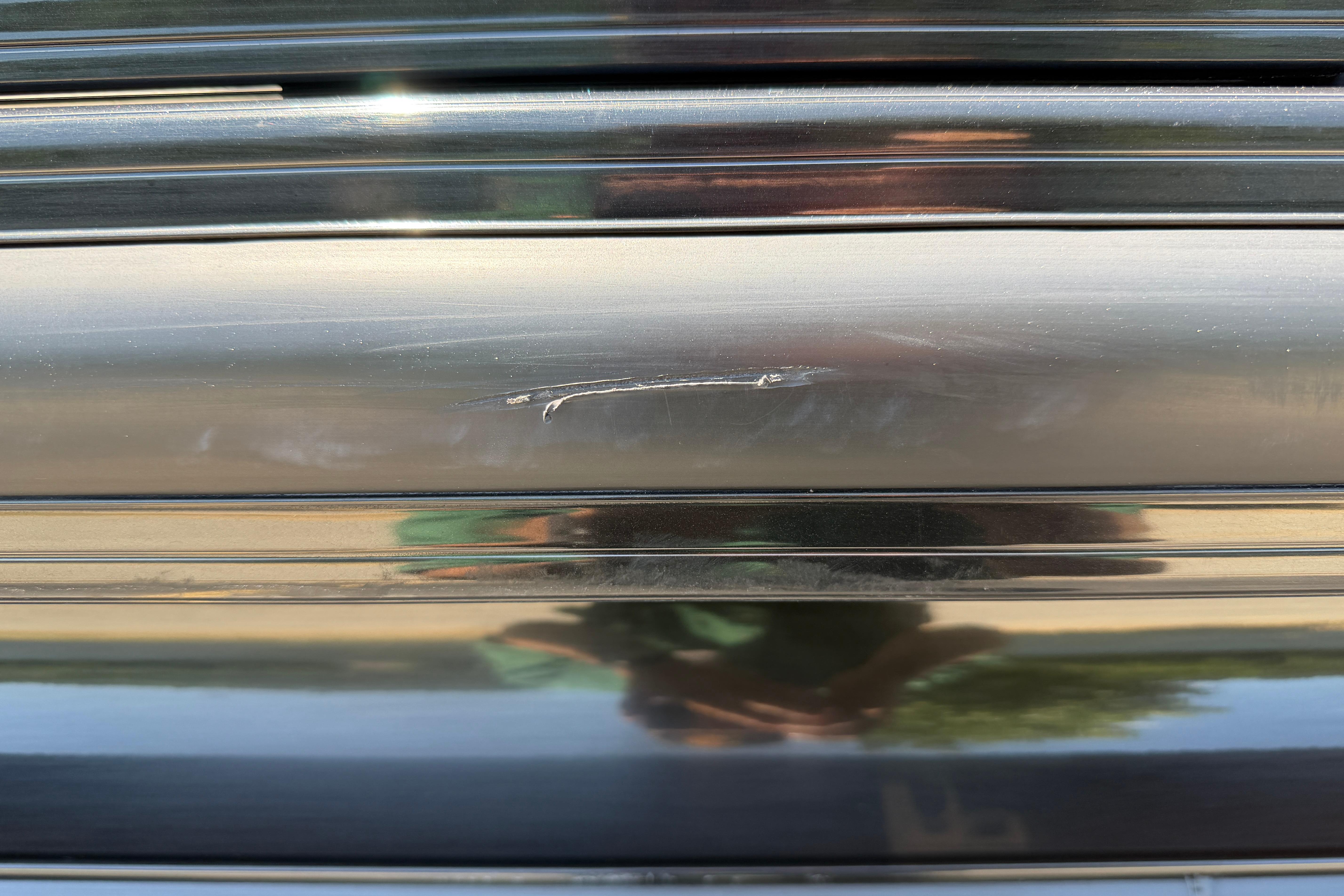 Scratch on 2024 Regency R250DL3 black surface, reflecting surroundings.