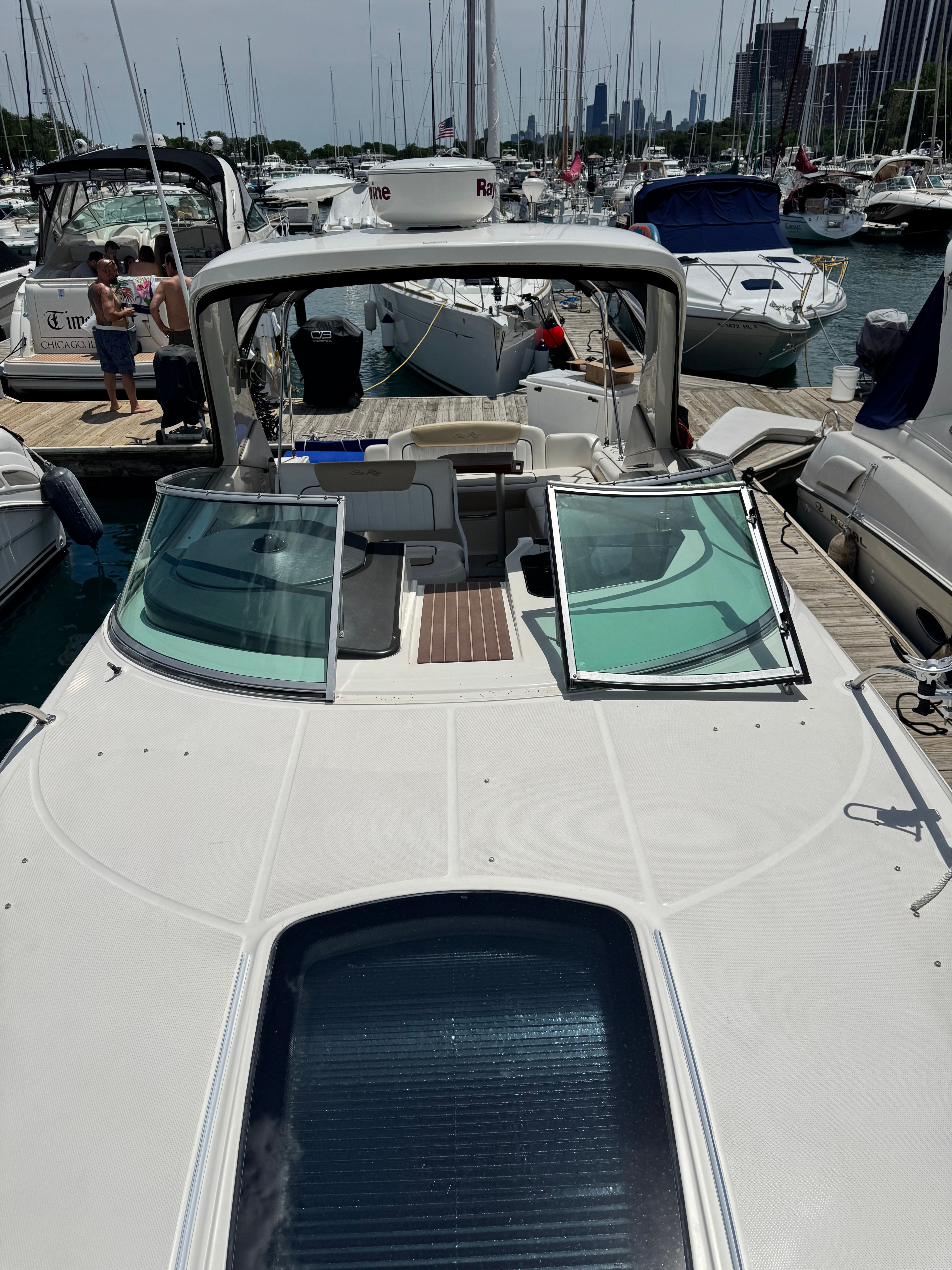 A 2010 Sea Ray Sundancer 310 docked in a busy marina.