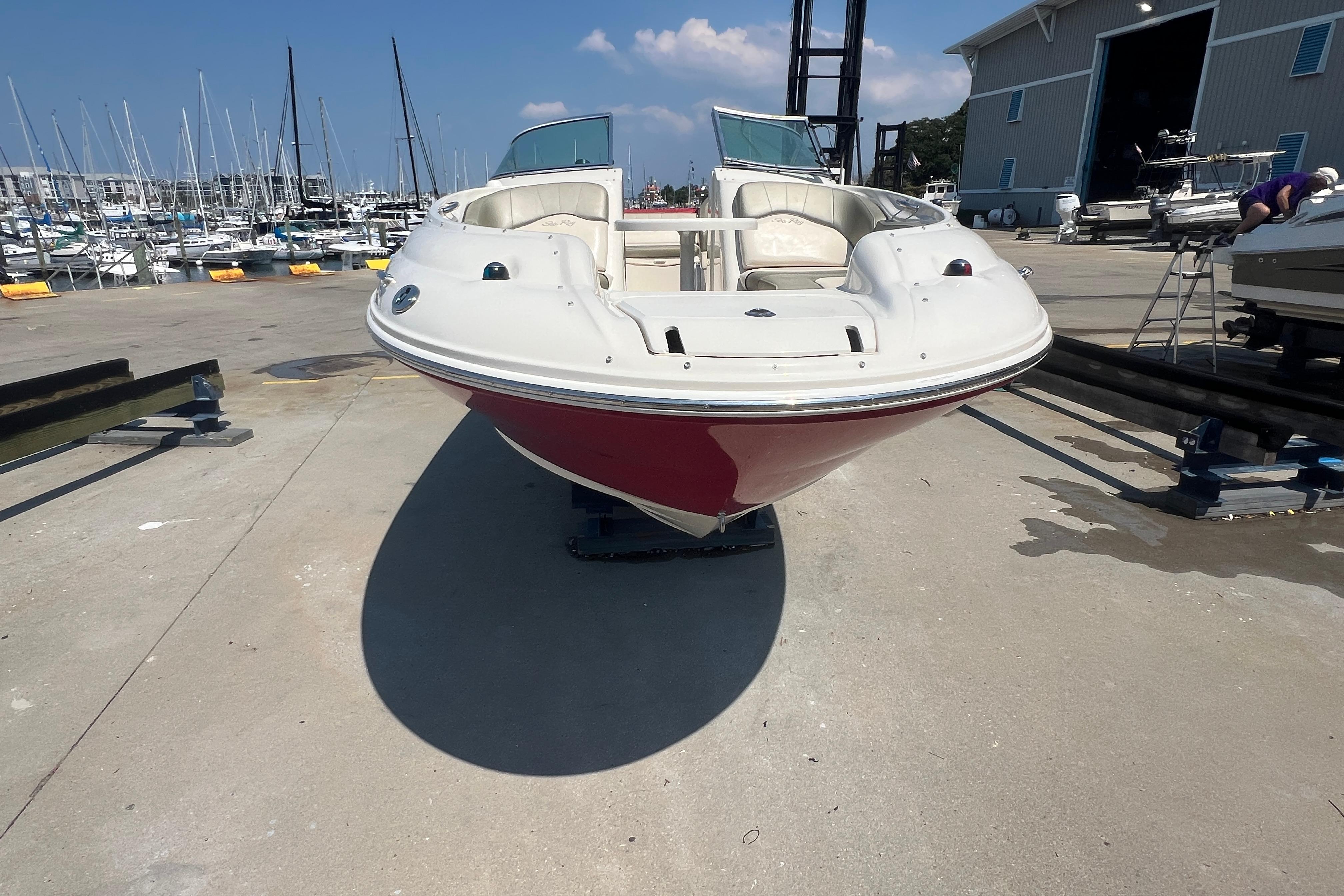 2005 Sea Ray 240 Sundeck boat on dry dock, marina background, sunny day.
