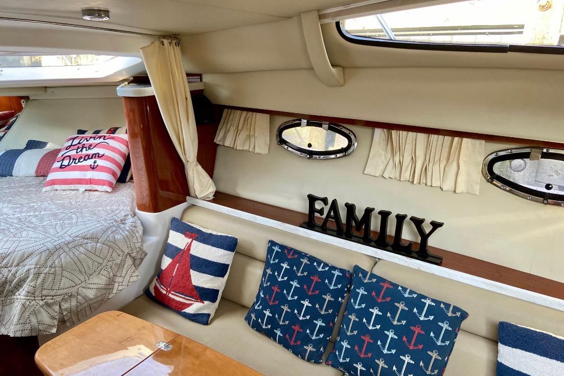 Interior of 2012 Regal 35 Express Cruiser with nautical-themed decor and cozy seating.