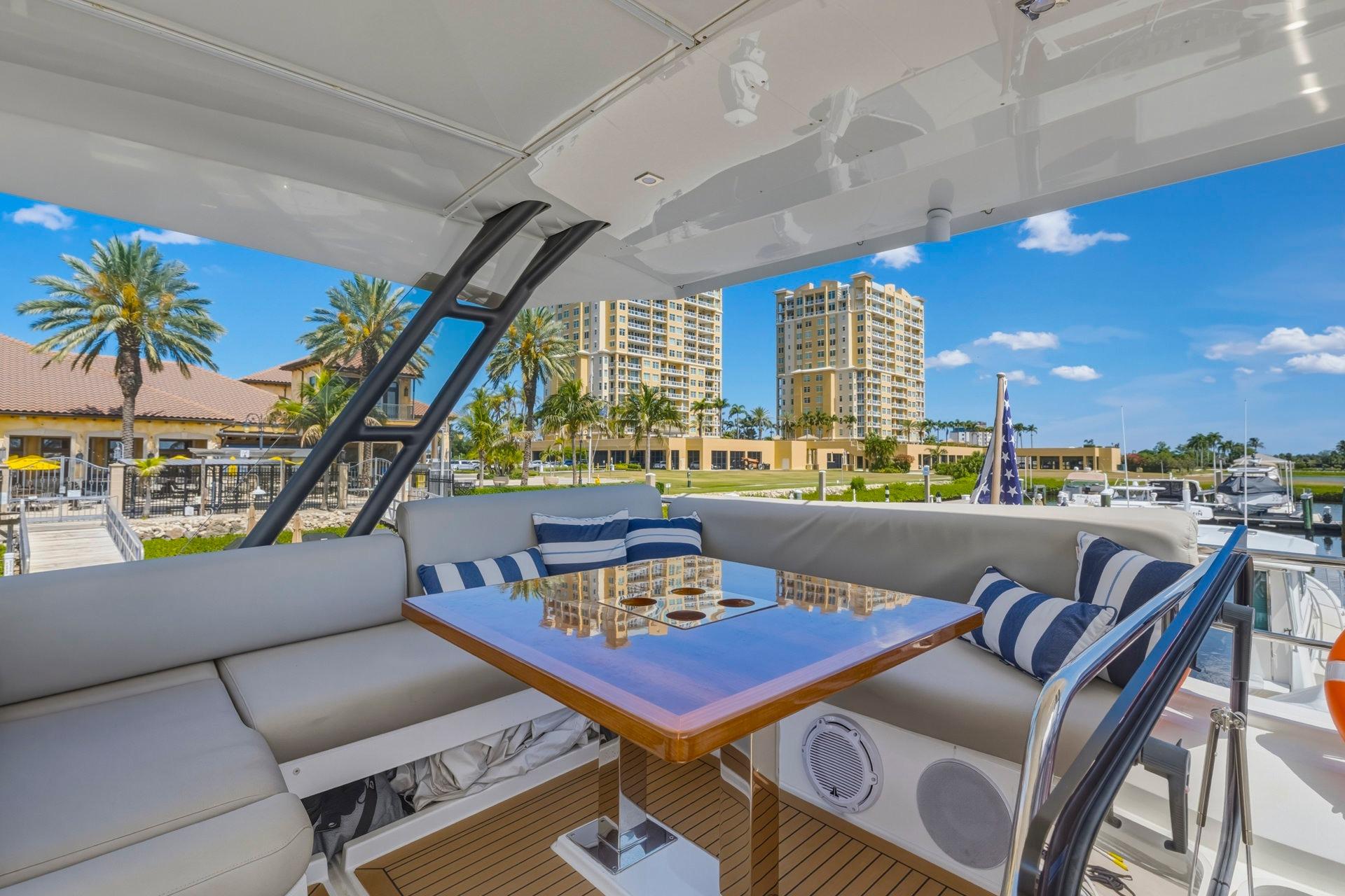 Luxurious 2022 Prestige 520 yacht interior with elegant seating and scenic marina view.