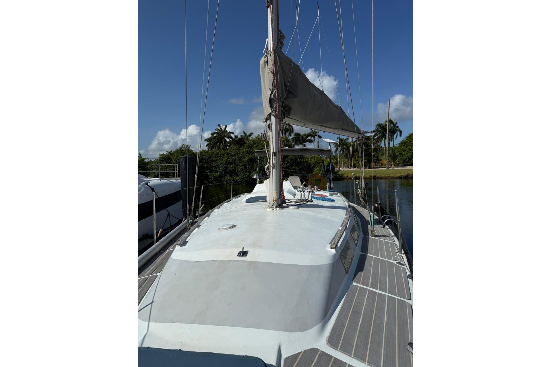 1982 Dufour 4800 sailboat docked, featuring a sleek deck and mast under clear skies.