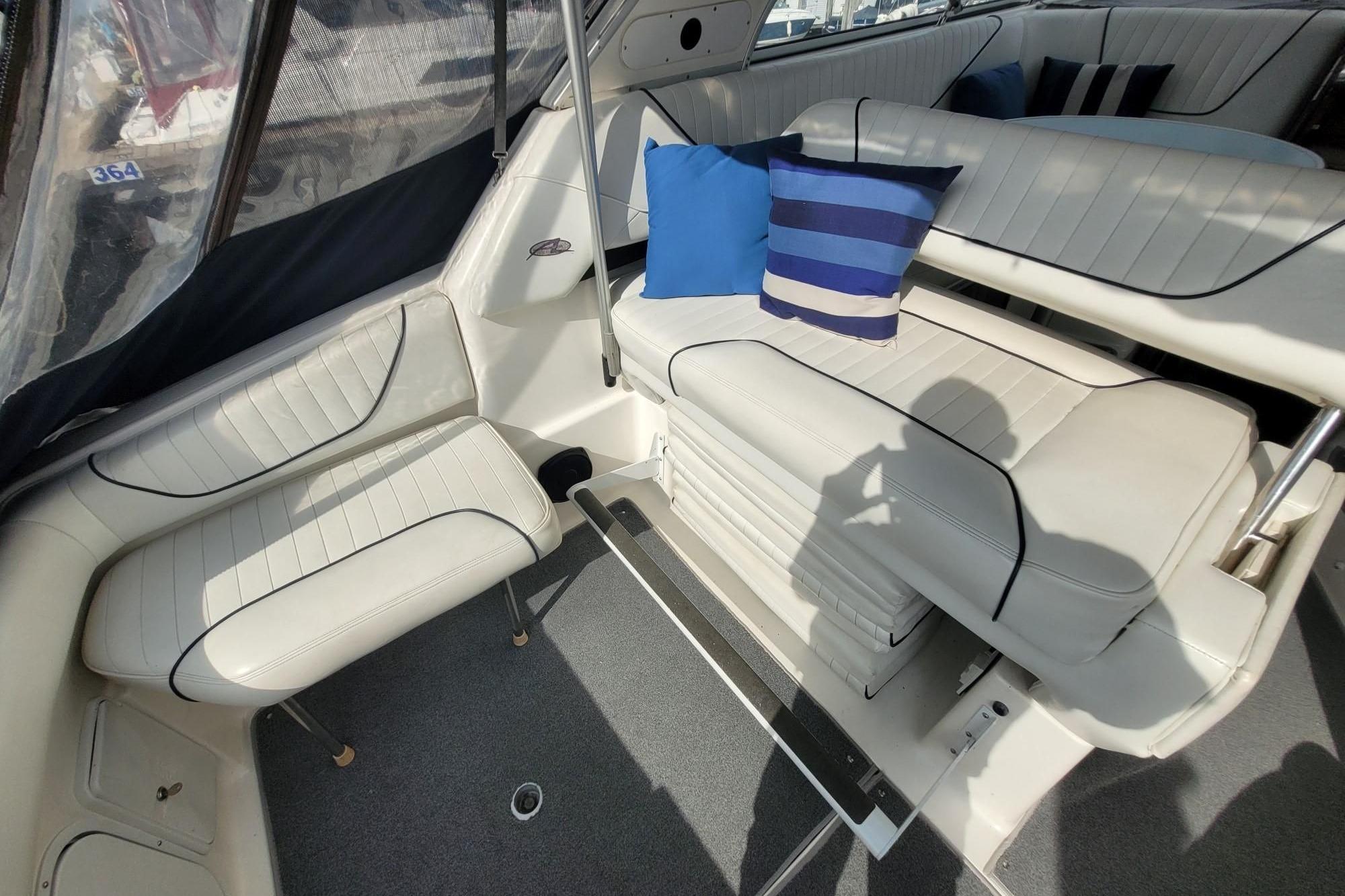 Interior of 1999 Bayliner 3255 Avanti boat with white seating and blue cushions.