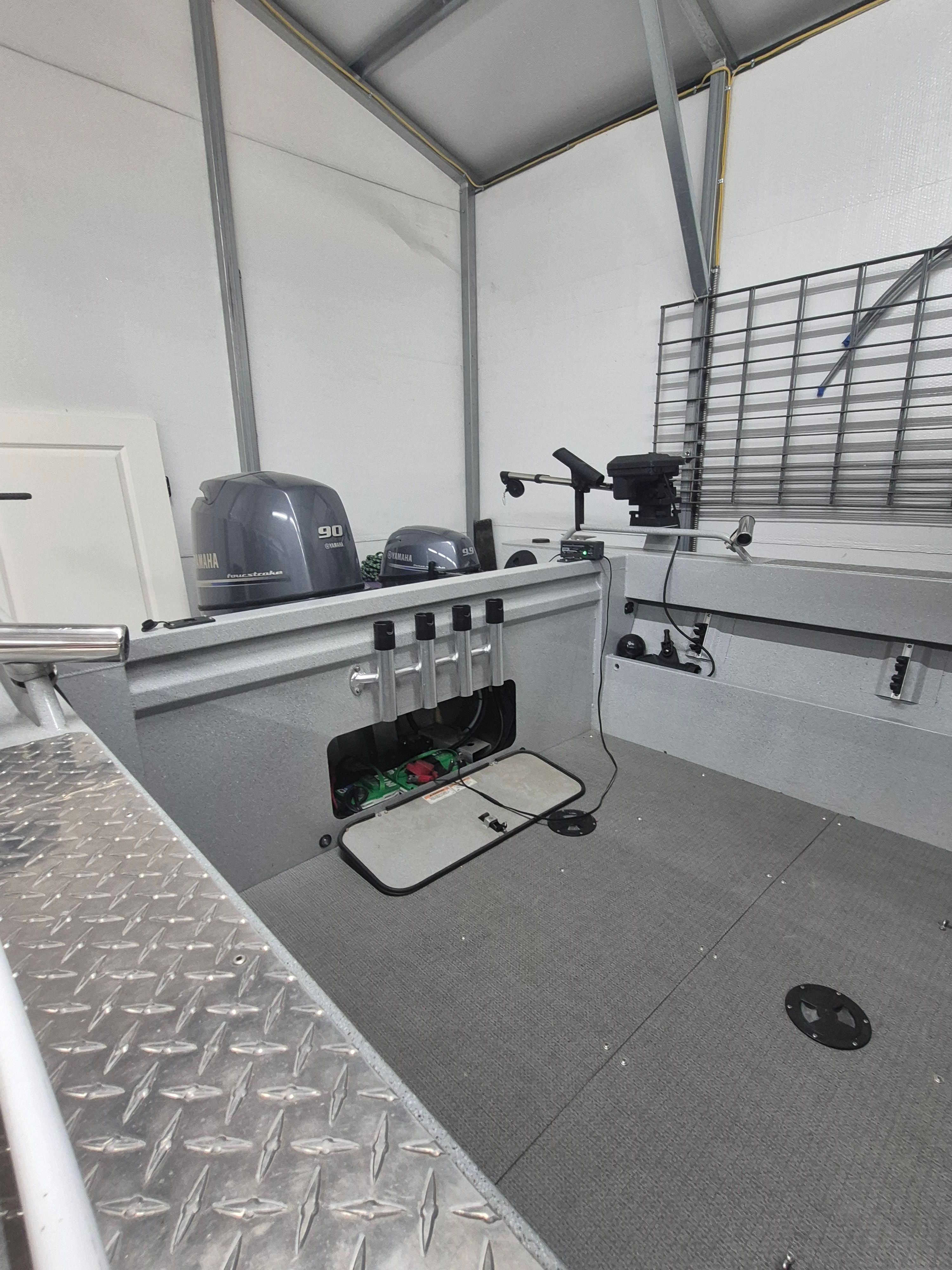 Interior view of a 2016 Duckworth 18 Advantage boat with motor and fishing rod holders.