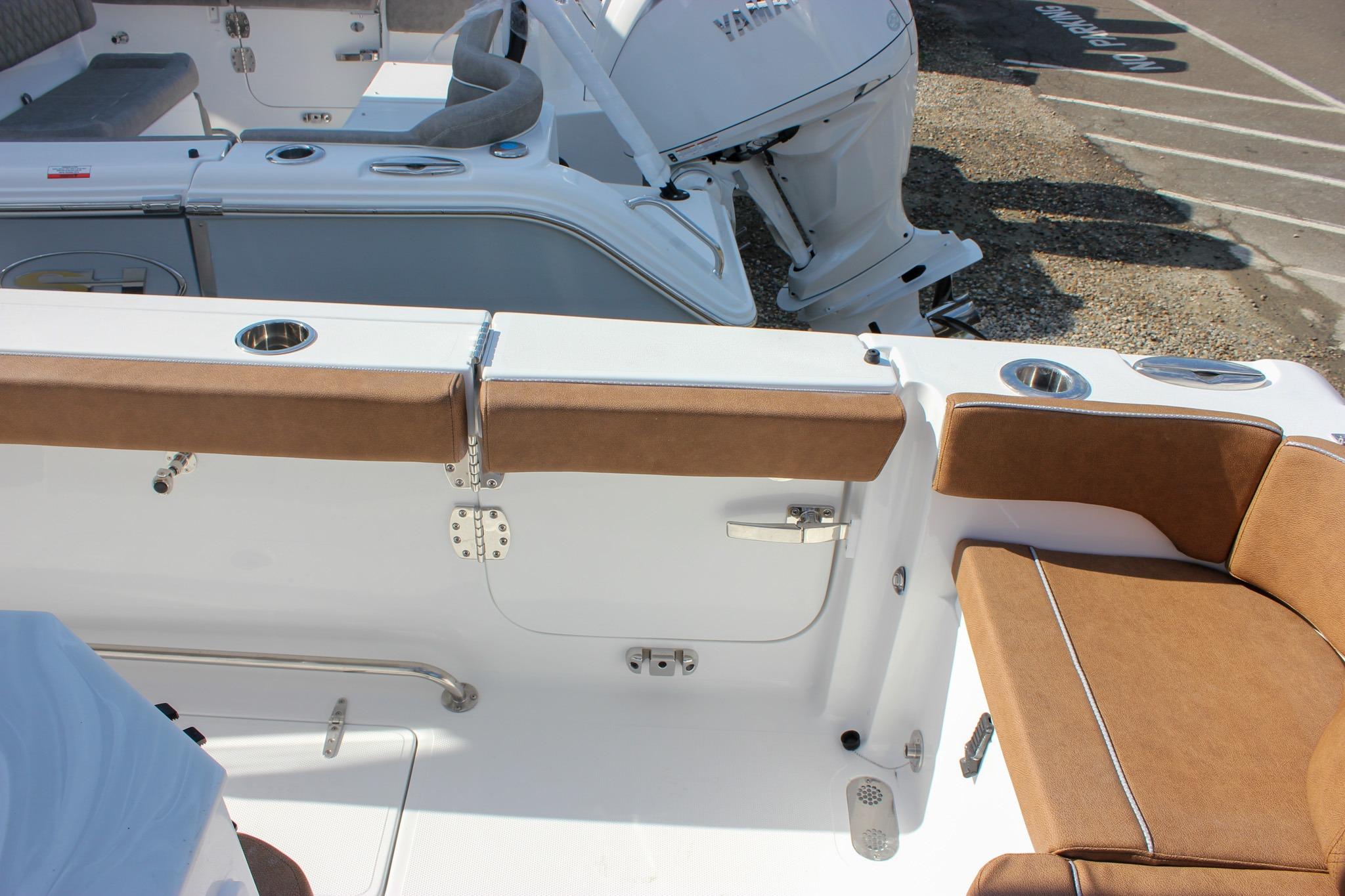 Interior view of a 2027 Sea Hunt Ultra 275 SE boat with brown seating and cup holders.