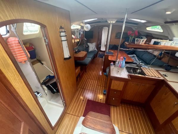 Interior of a 2000 Hunter 410 with wooden floors and a cozy seating area.