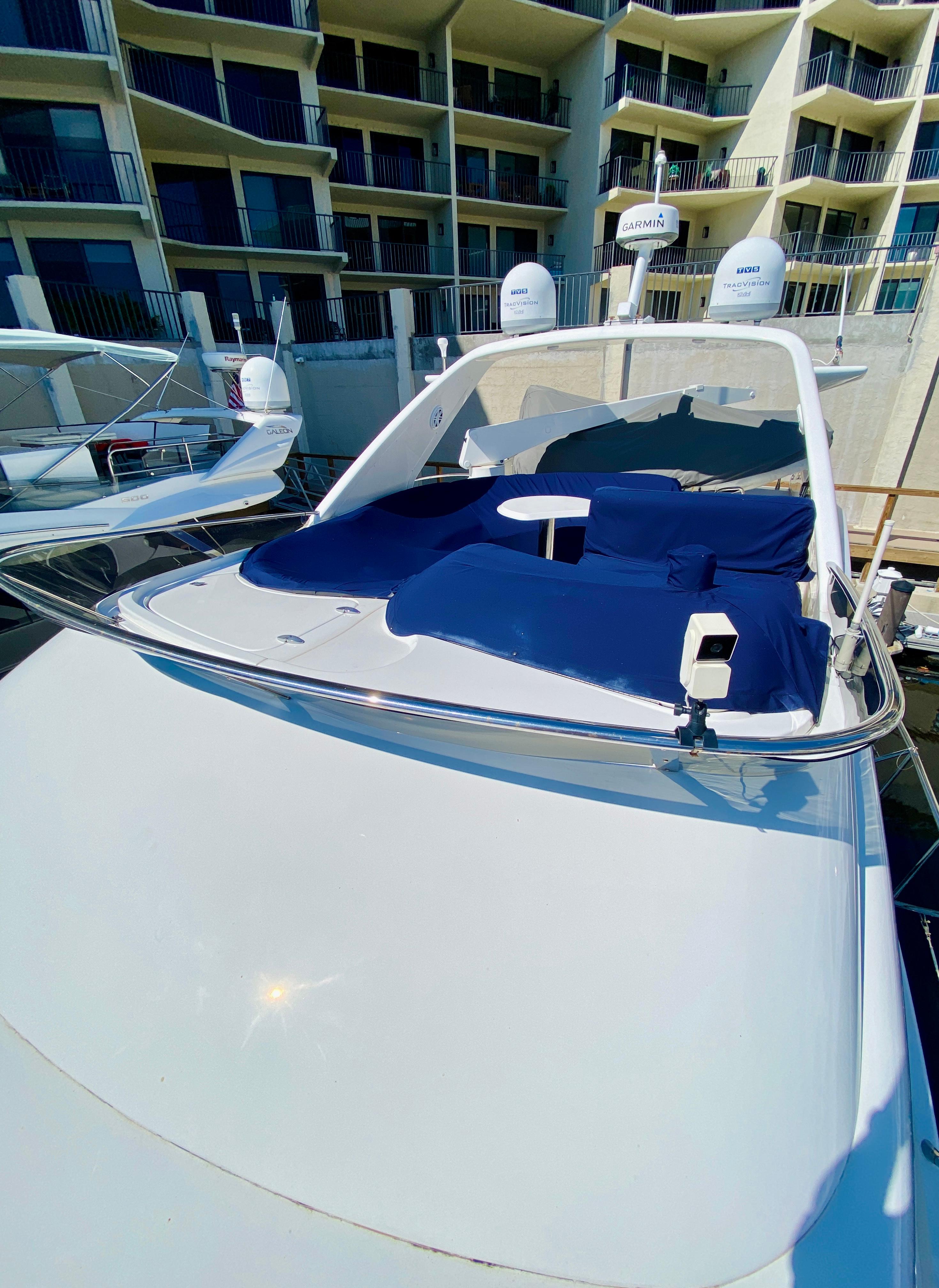 Azimut 55 yacht, 2002 model, docked with blue sunbathing area, modern design.