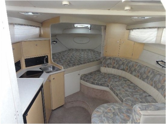 Interior of 2000 Bayliner 3055 Ciera Sunbridge with kitchenette and seating area.