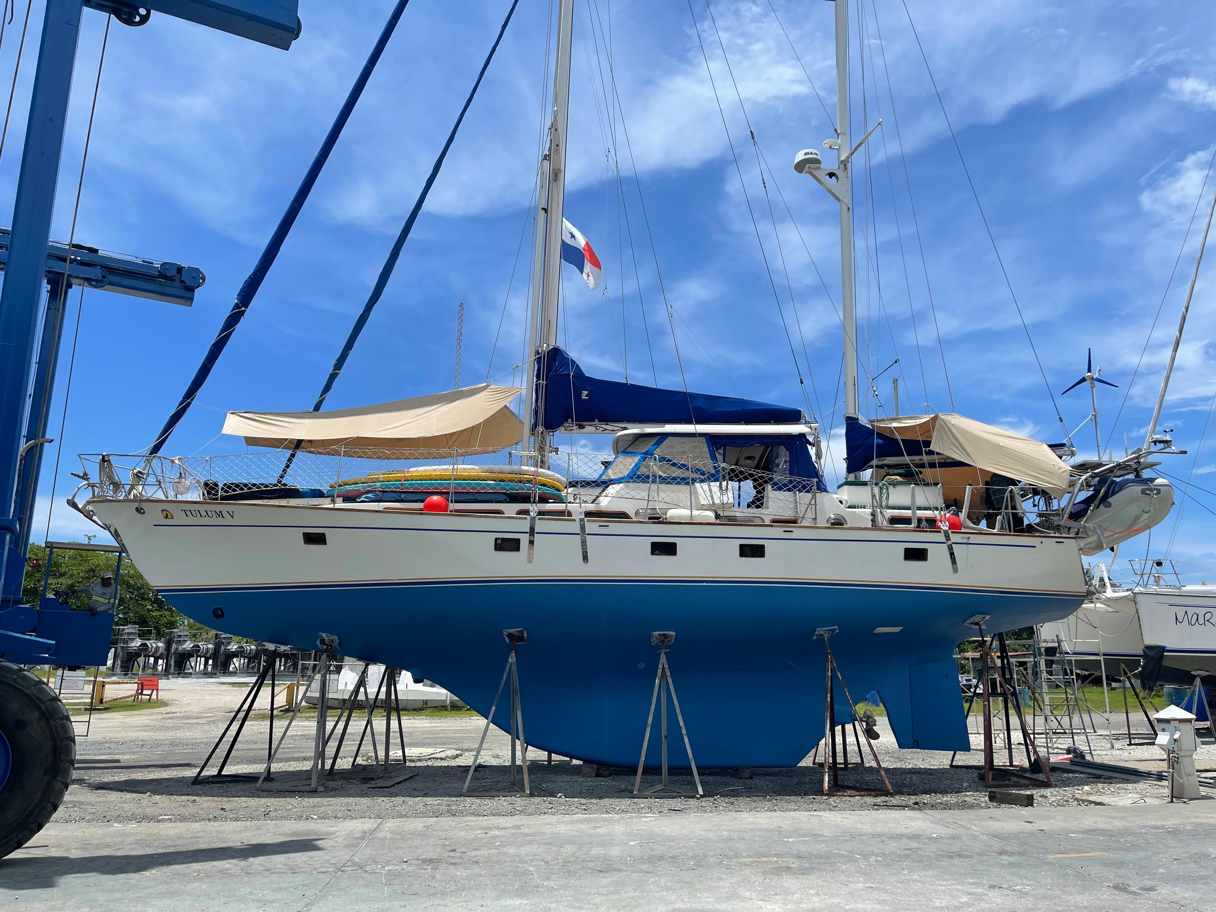 1977 Aleutian 51 sailboat on stands, blue hull, clear sky background.