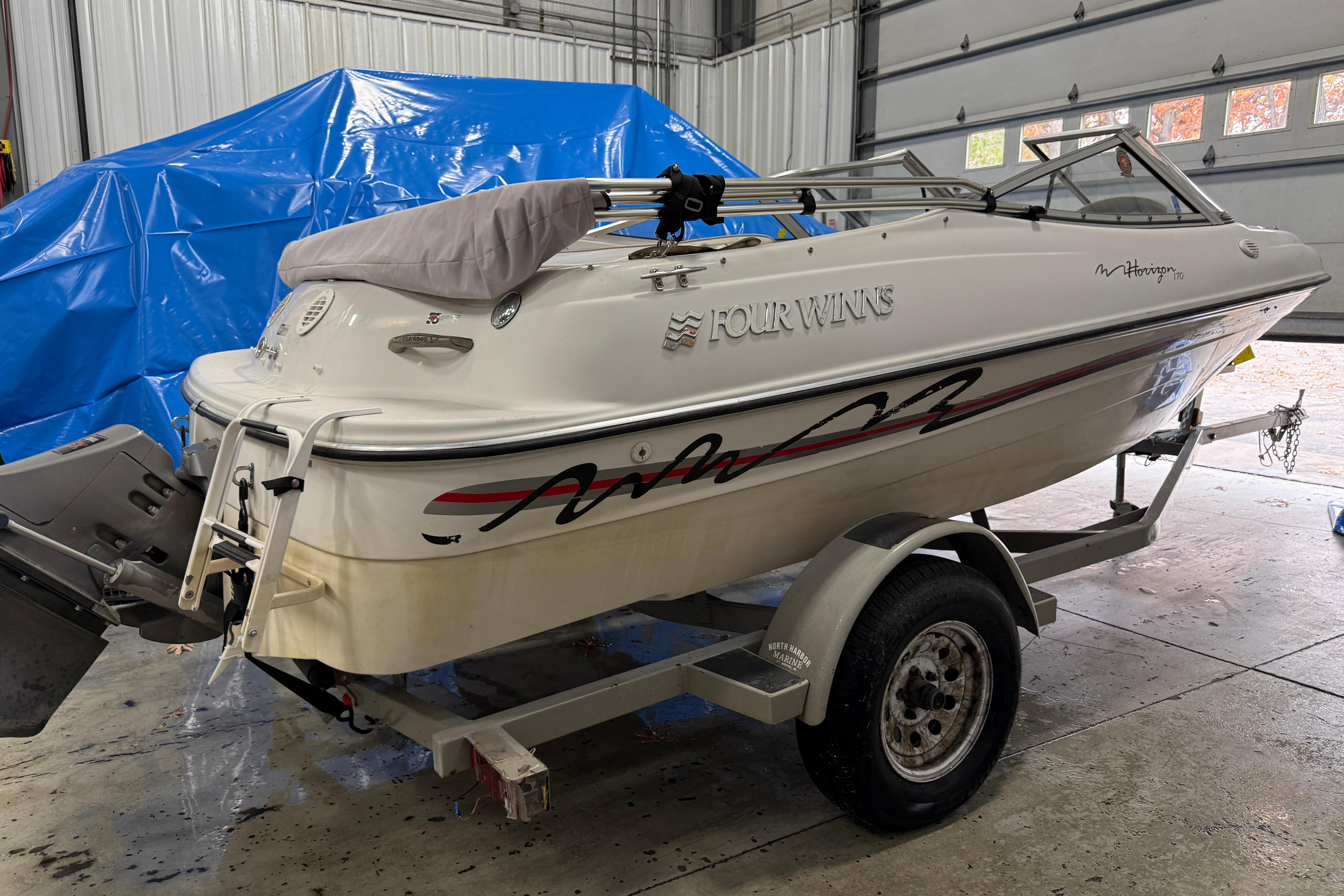 1999 Four Winns 170 Horizon LE boat on trailer in garage setting.