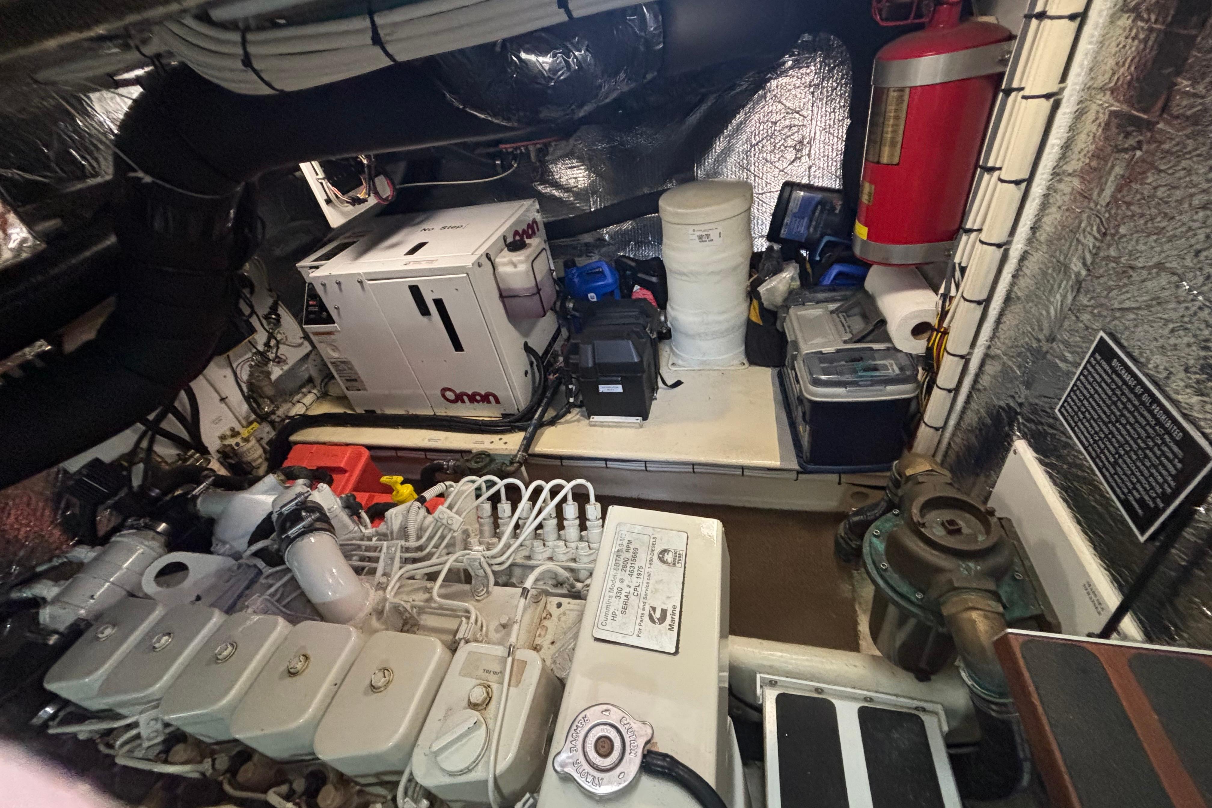 Engine room of a 2004 Nordic Tug 37 with Onan generator and fire extinguisher.