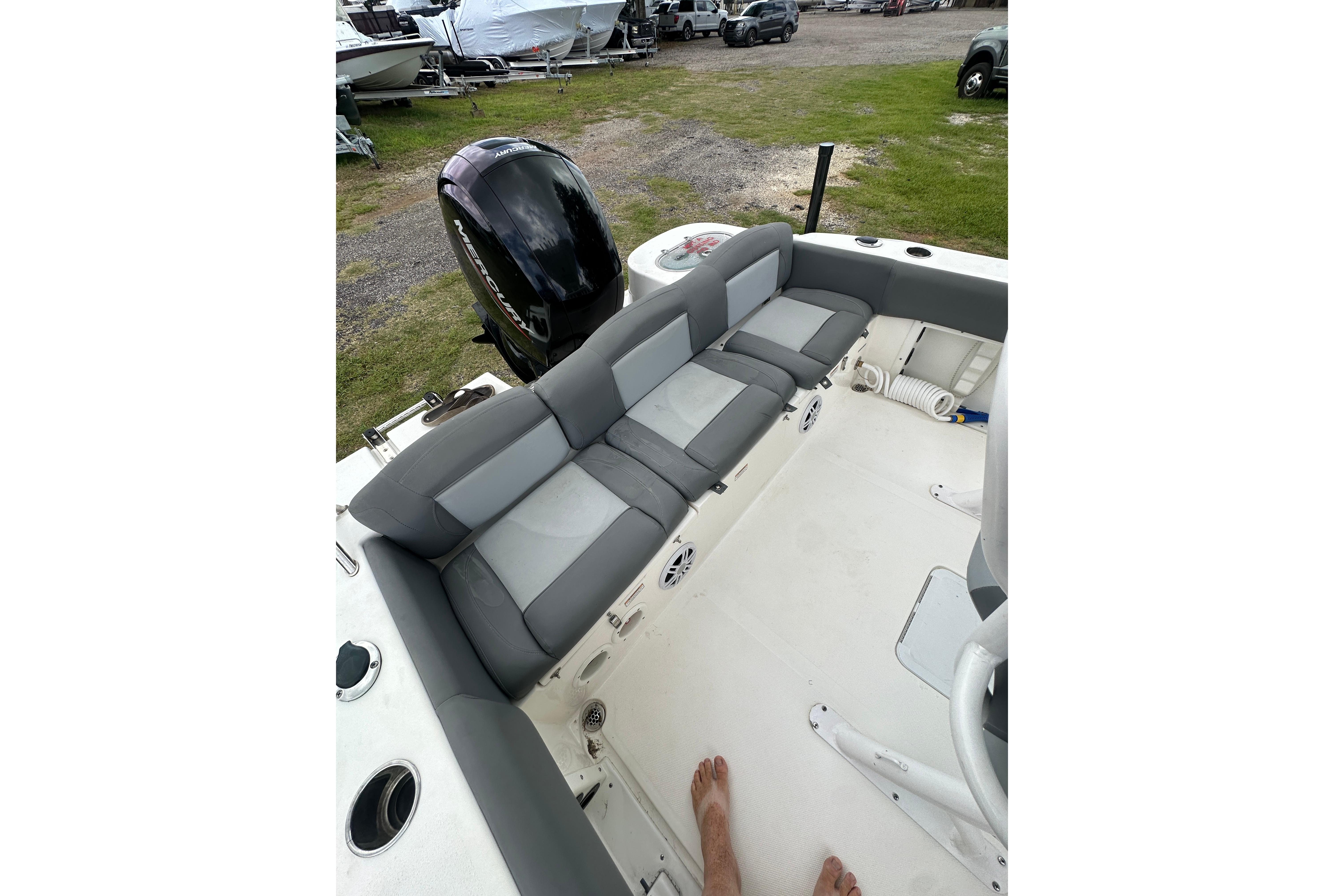 2023 NauticStar 2102 Legacy boat interior with cushioned seating and outboard motor.