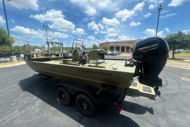 2026 Tracker Grizzly 2072 CC Sportsman boat with Mercury engine in parking lot.
