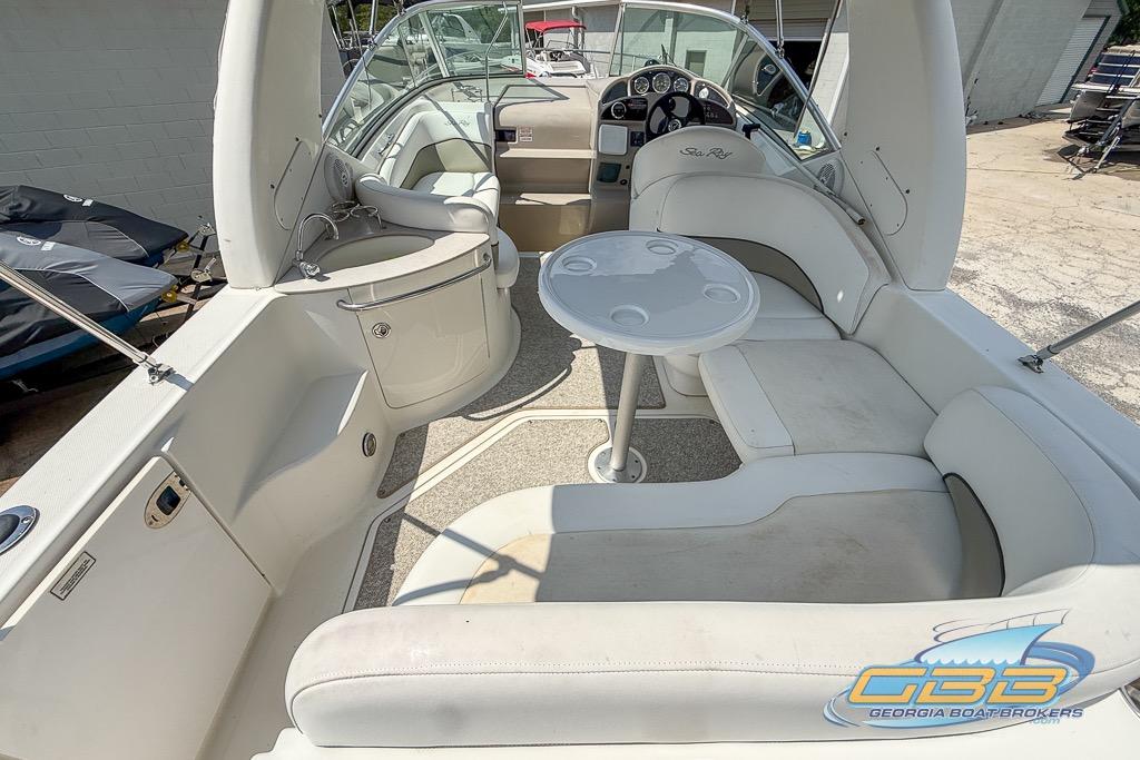 2006 Sea Ray Sundancer 260 interior with seating, table, and helm, showcasing luxury design.