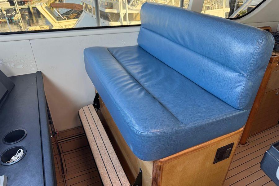 Blue leather seating on 2002 Viking 61 Enclosed Bridge yacht interior.