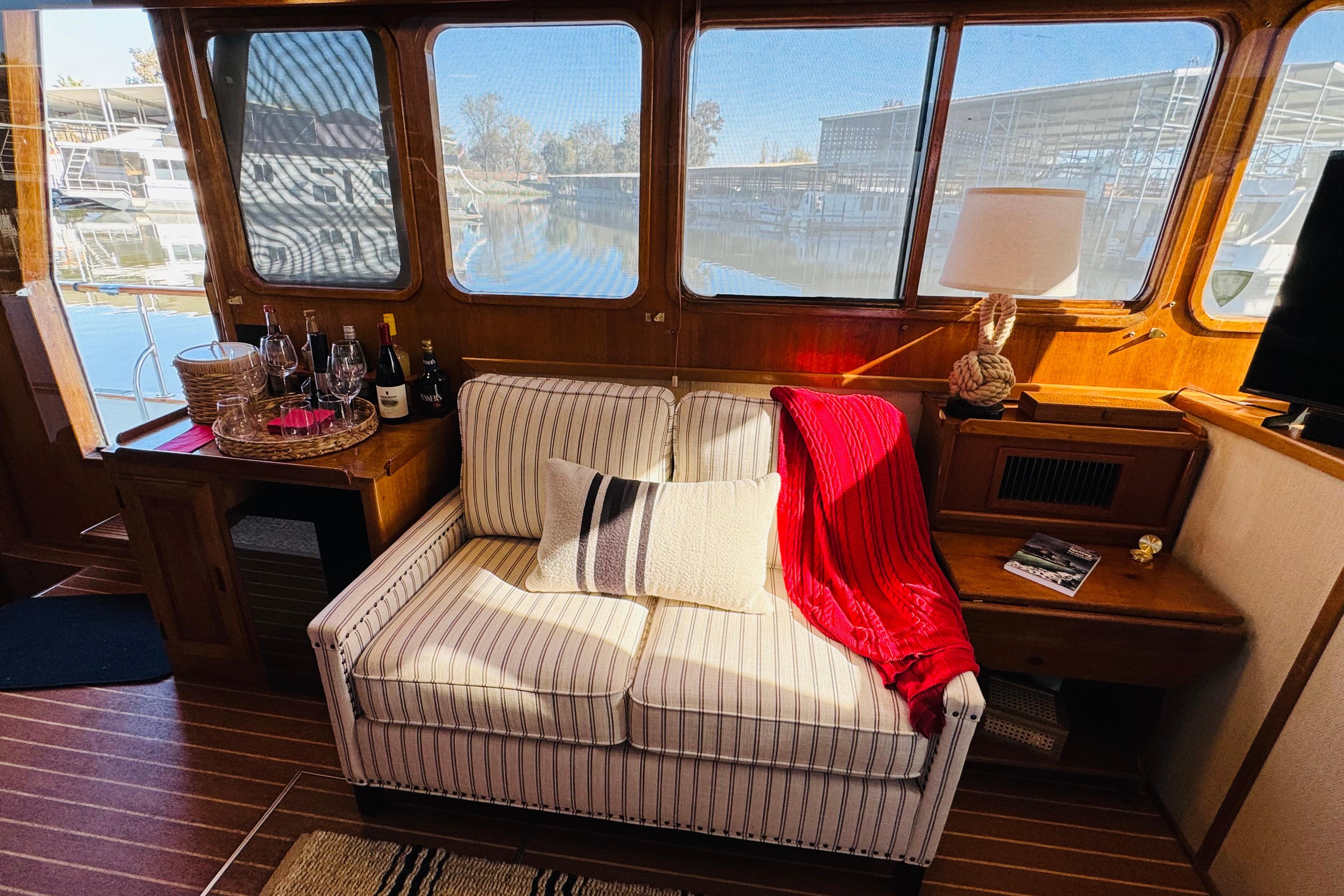 Interior of 1978 Californian 42 LRC yacht with cozy seating and scenic marina view.