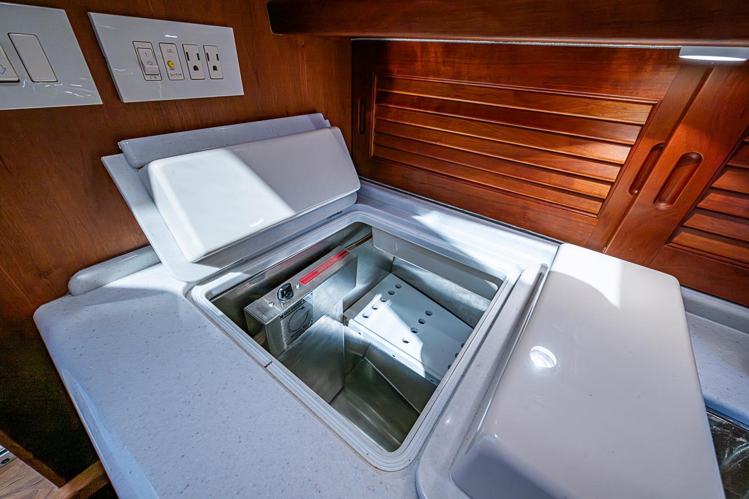 Interior of 2012 Hinckley Runabout 38 showing a built-in cooler and wooden cabinetry.