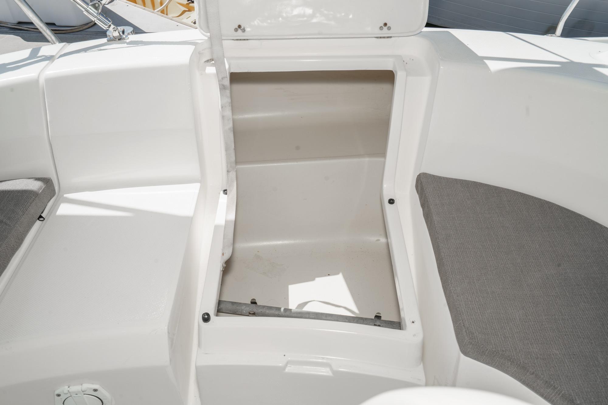 Open storage compartment on 1996 Hunter 376 sailboat deck with cushioned seating.