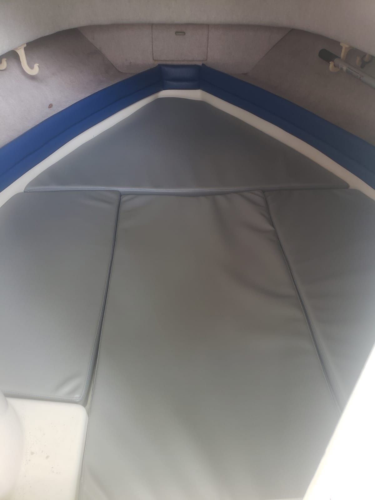 Interior of a 1995 Grady-White Explorer 24 with gray cushions and blue accents.